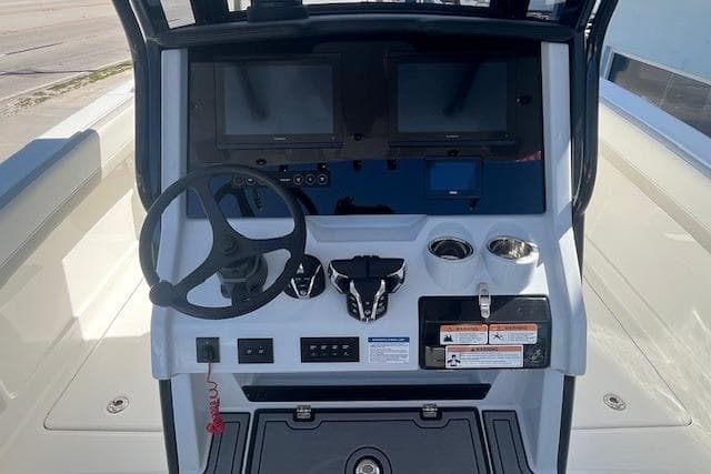 2026 World Cat 280 CC-X boat dashboard with steering wheel and dual screens.