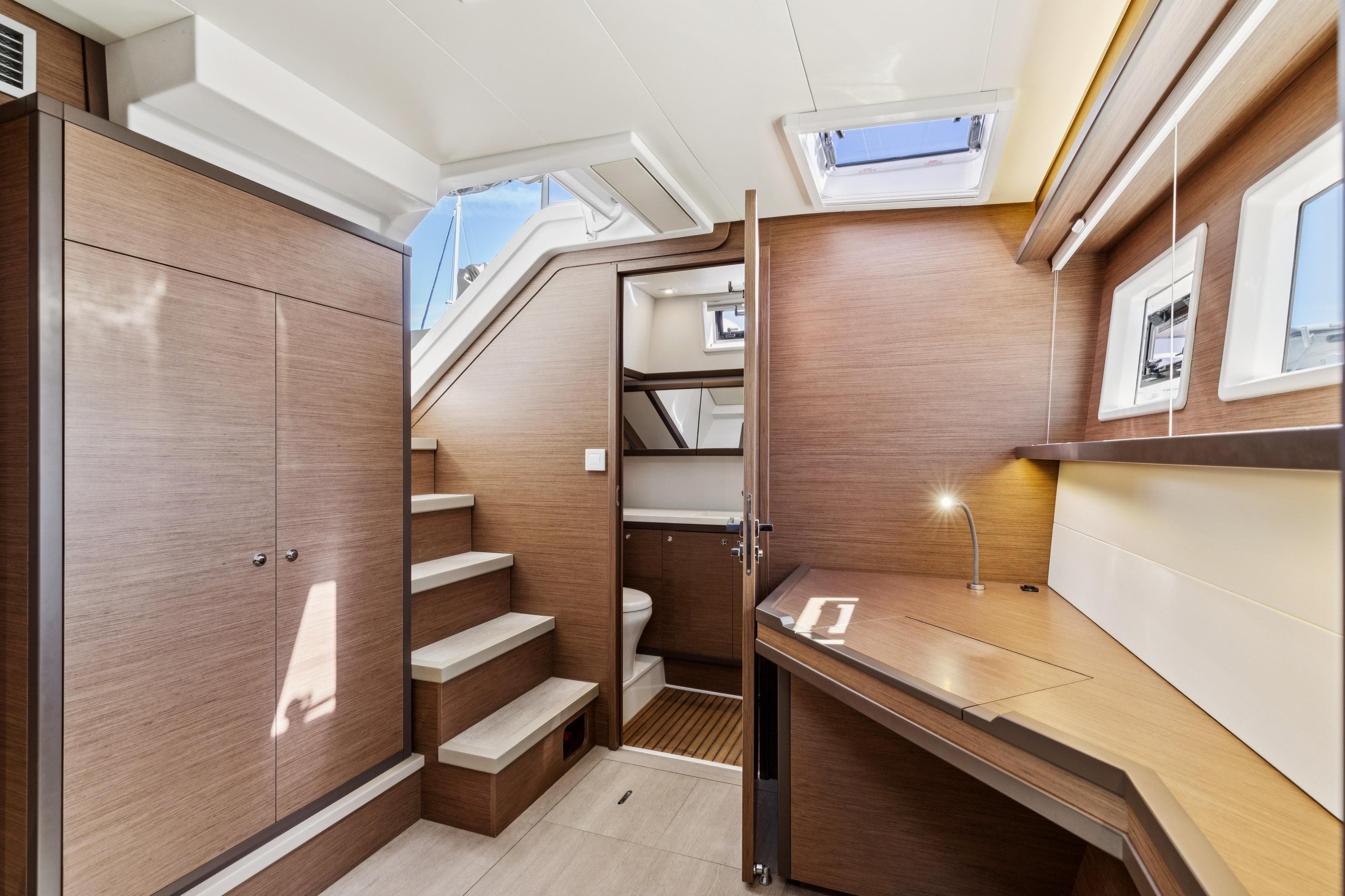 Luxurious interior of 2022 Lagoon 52 F yacht with modern wood finishes and skylights.