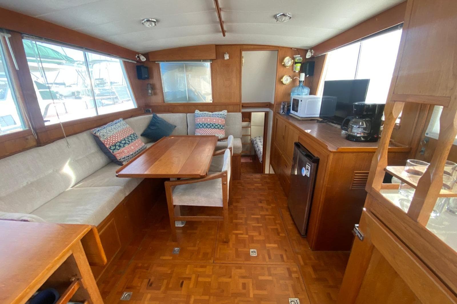 Interior of a 1977 Grand Banks 42 yacht with cozy seating and wooden furnishings.