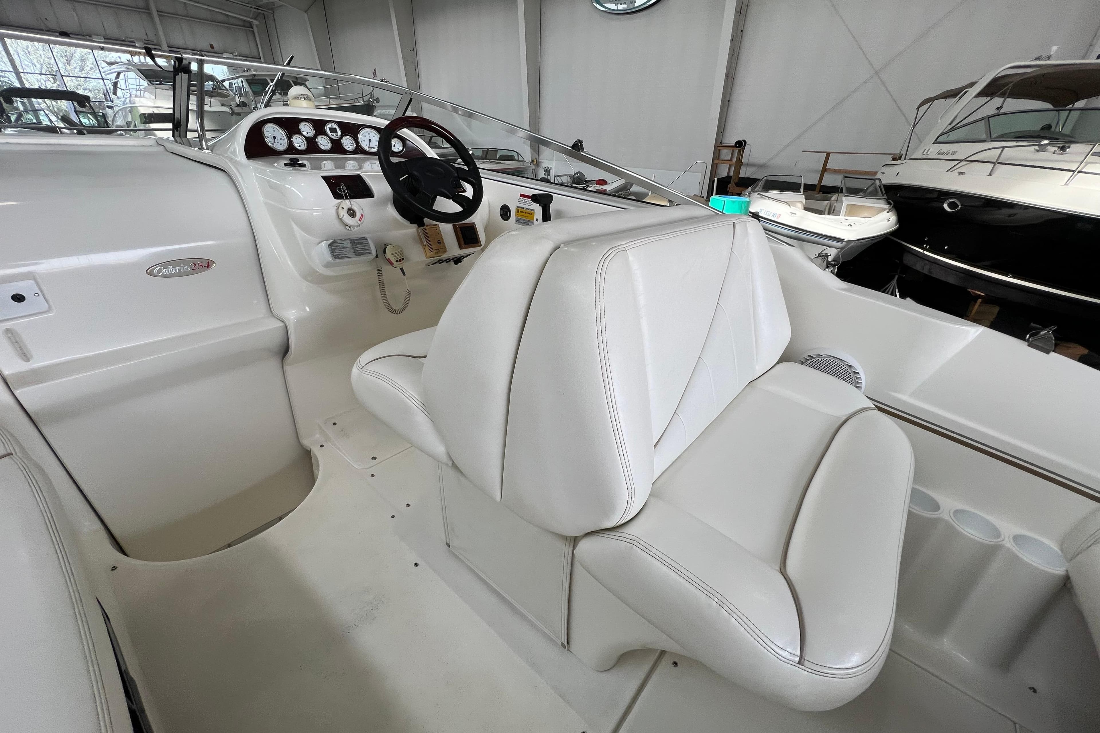 2002 Larson Cabrio 254 boat interior with white seating and control panel.