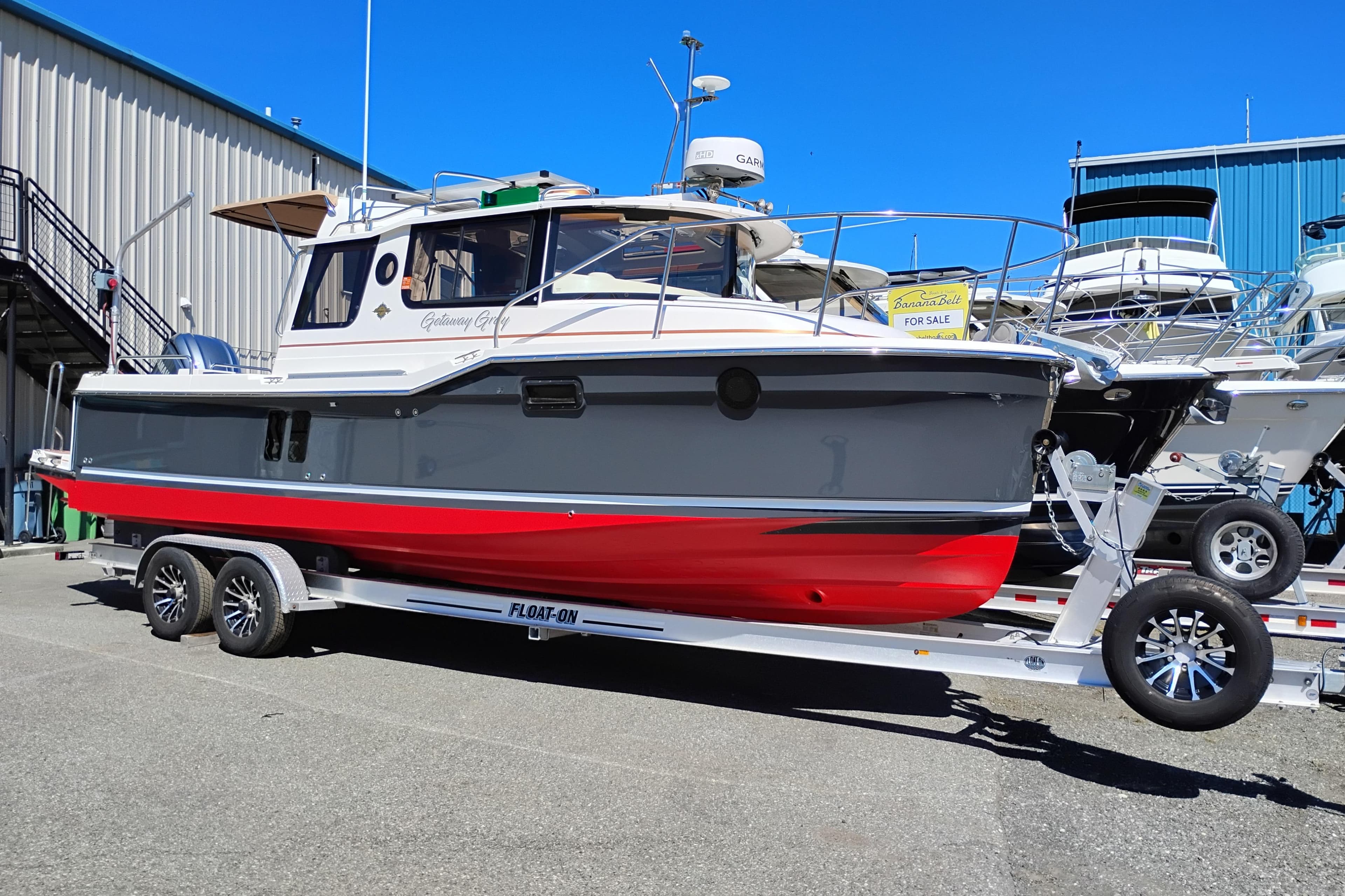2023 Ranger Tugs R-25 boat on trailer, displayed outdoors for sale.
