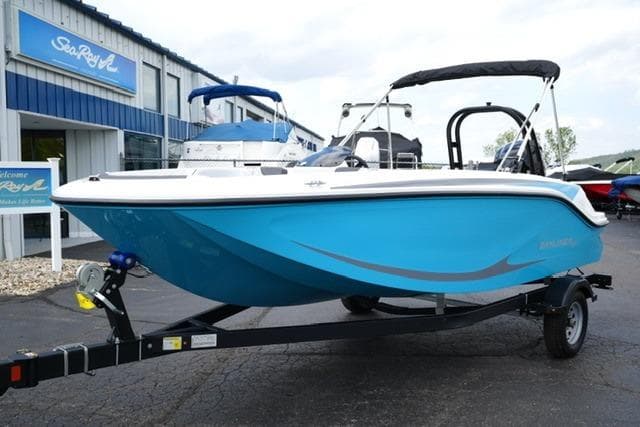 2026 Bayliner M17 boat in blue on a trailer outside a dealership.