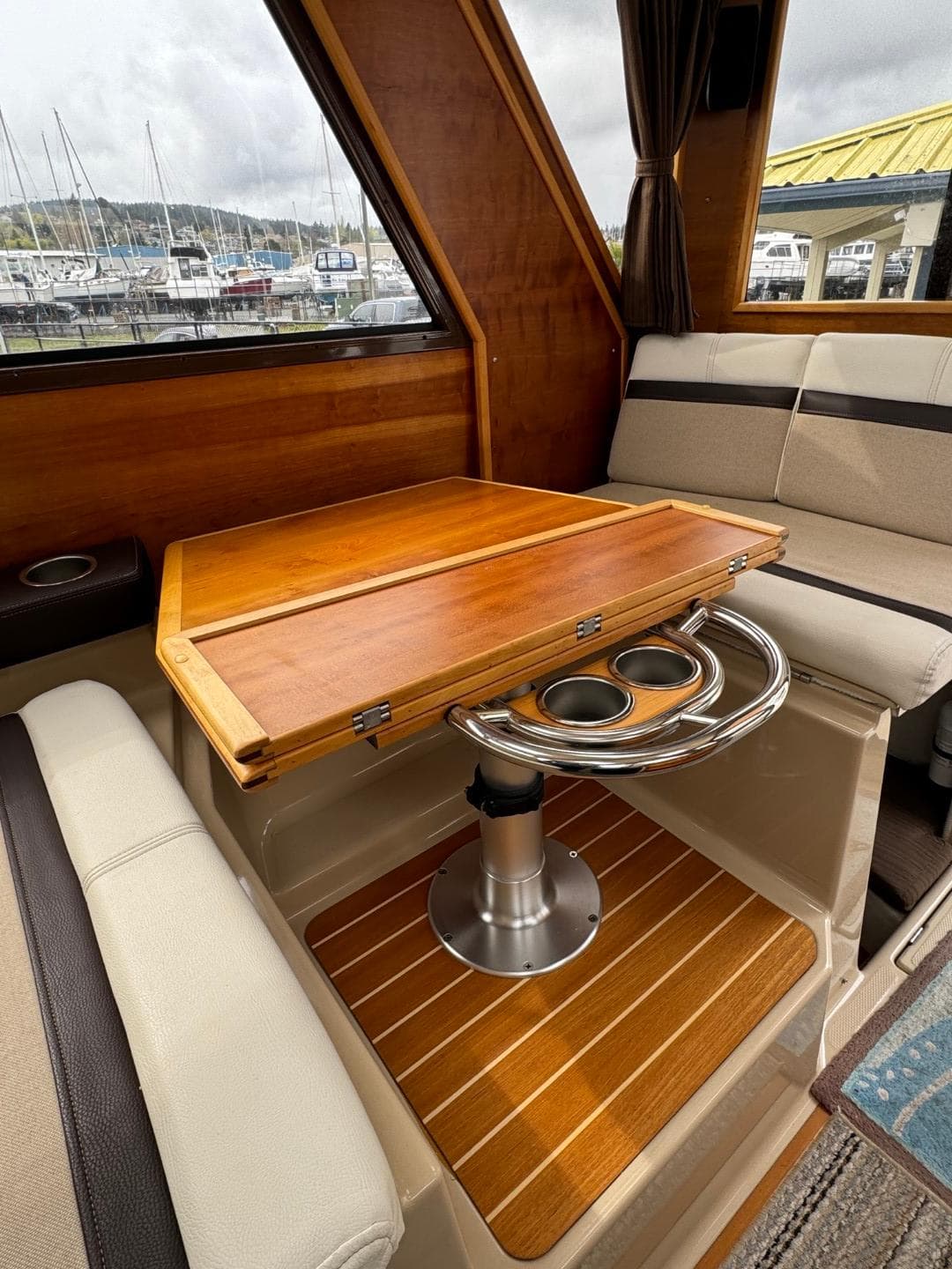 2017 Cutwater C28 interior with wooden table, cushioned seating, and cup holders.