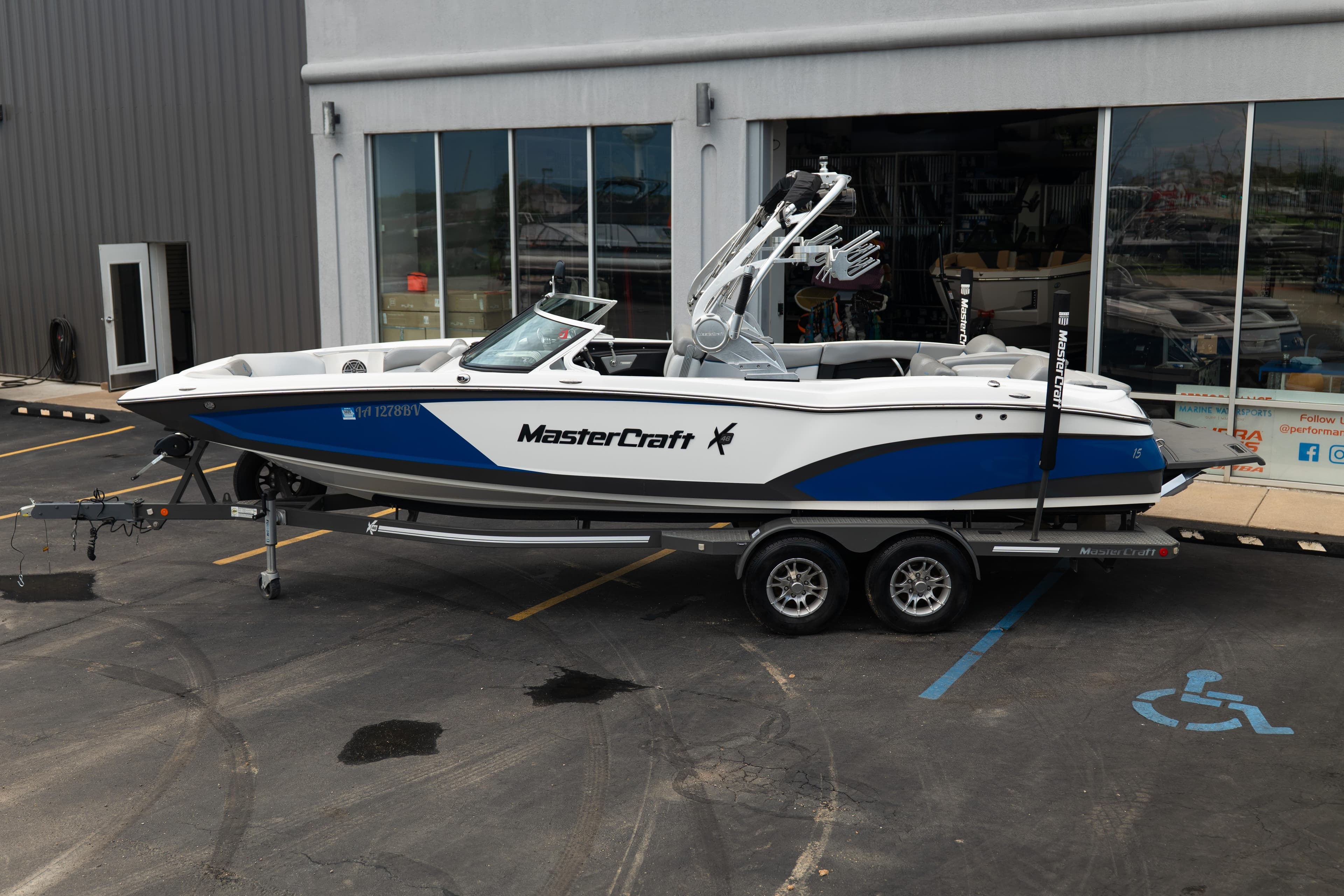 2016 MasterCraft X46 boat on trailer, parked outside a showroom.