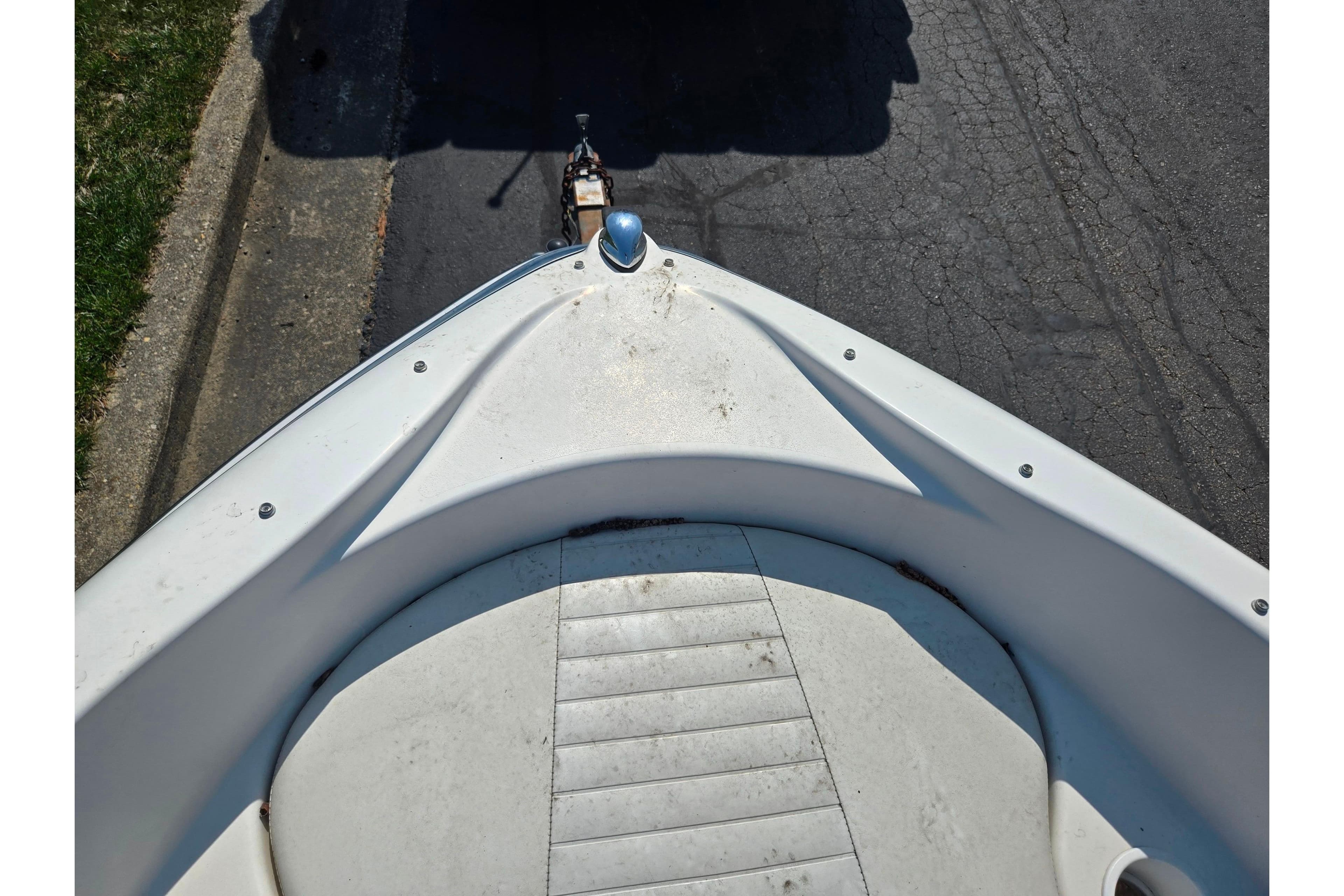 2007 Glastron GT 185 boat bow view on a trailer, parked on pavement.