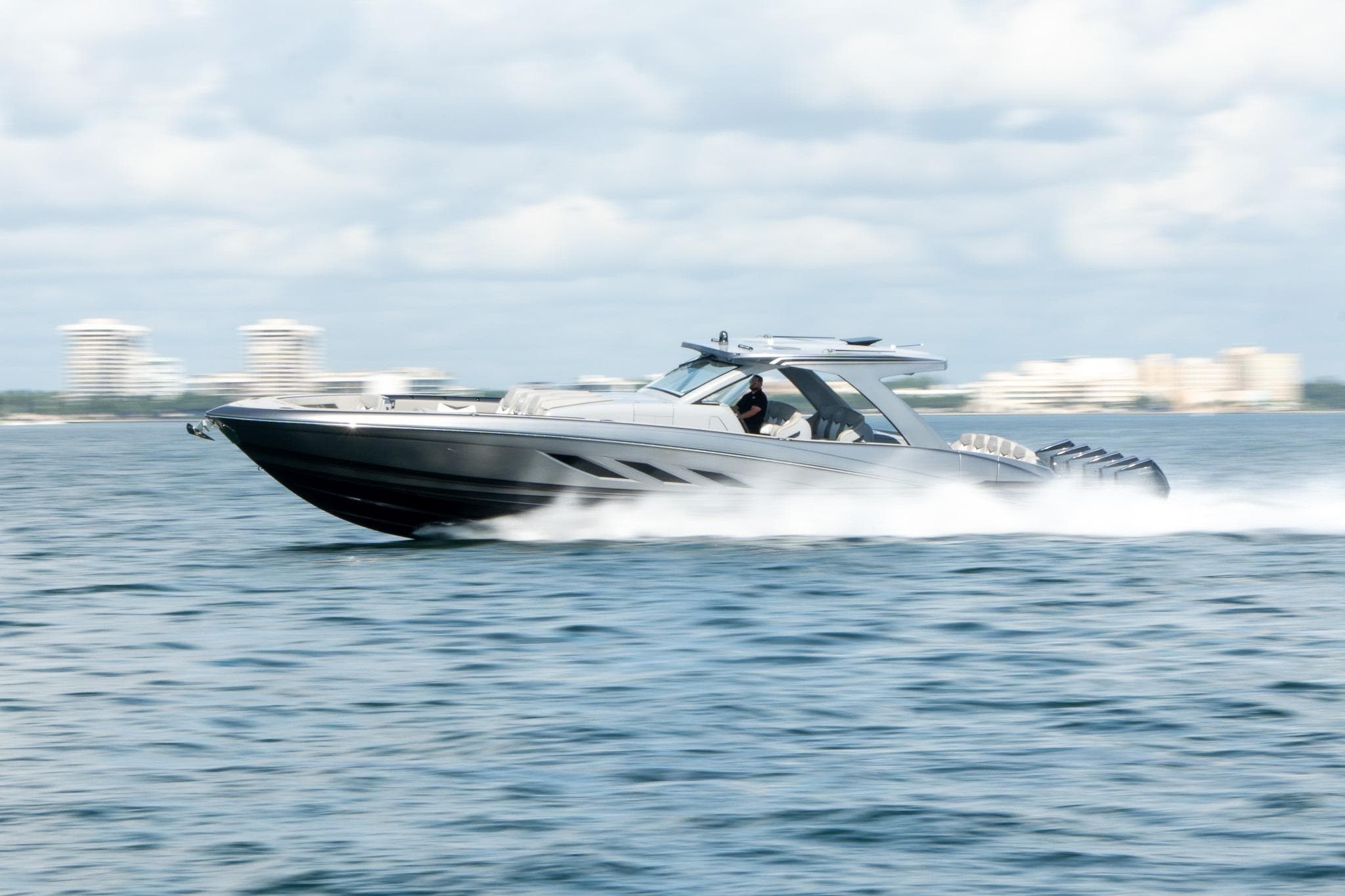 2026 Deep Impact 499 Sport boat speeding on open water, with cityscape in background.