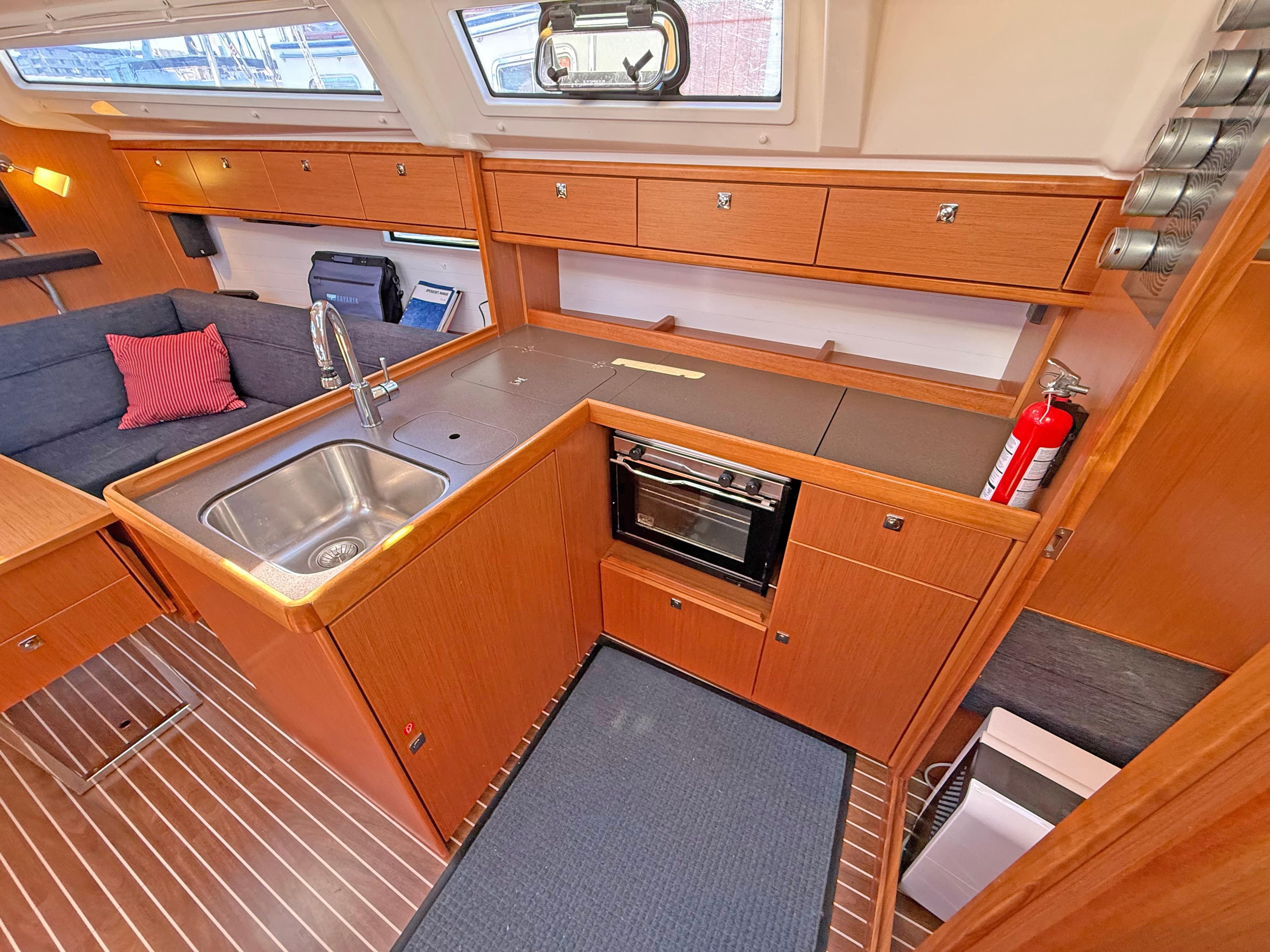 Interior of 2015 Bavaria Cruiser 37 yacht kitchen with wood cabinetry and modern appliances.