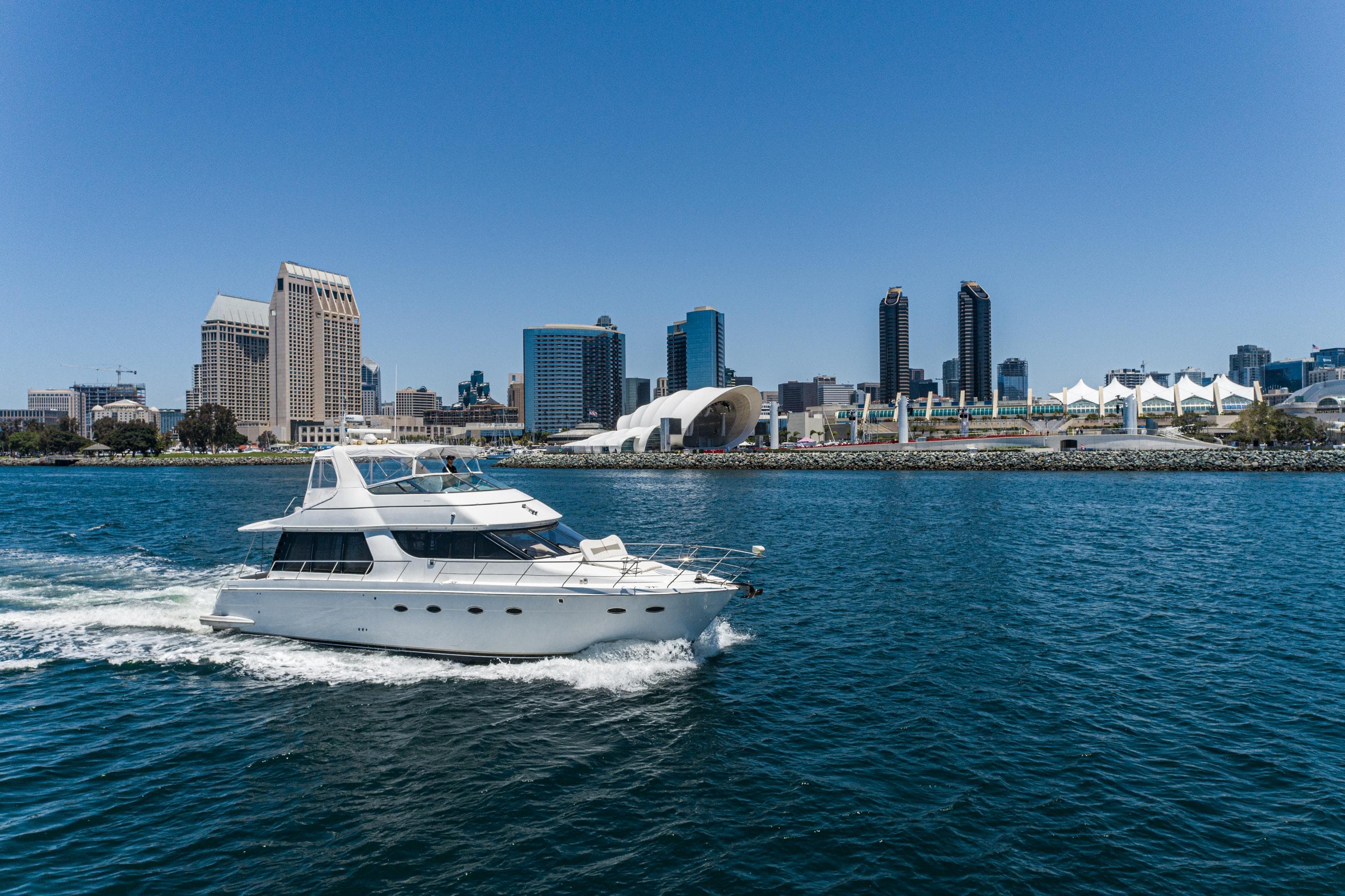 1999 Carver 530 Voyager Pilothouse yacht cruising near city skyline.