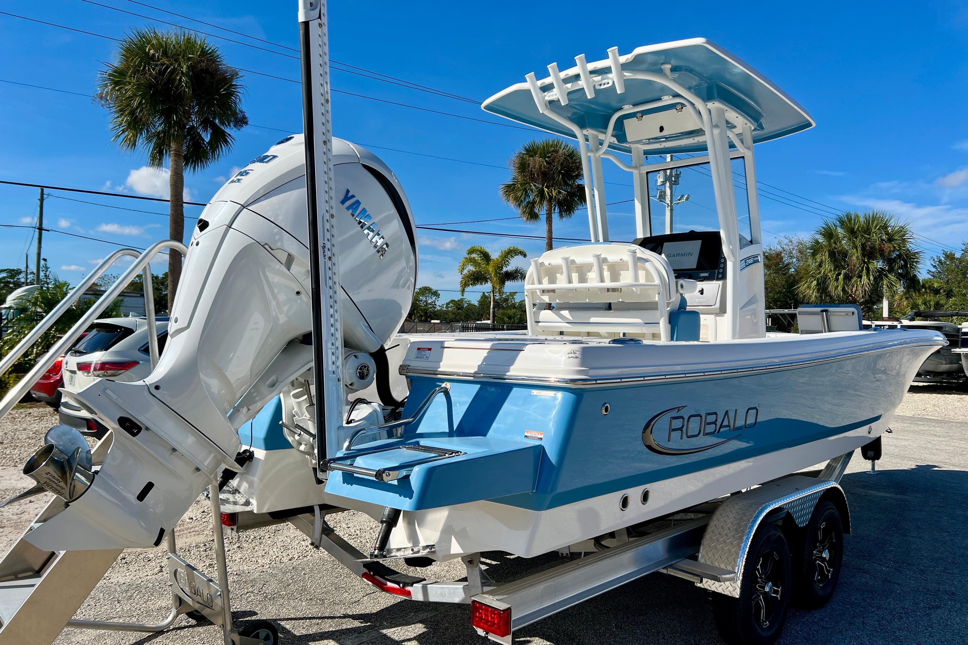 2026 Robalo 246 Cayman boat with Yamaha engine, parked on a trailer under clear blue skies.