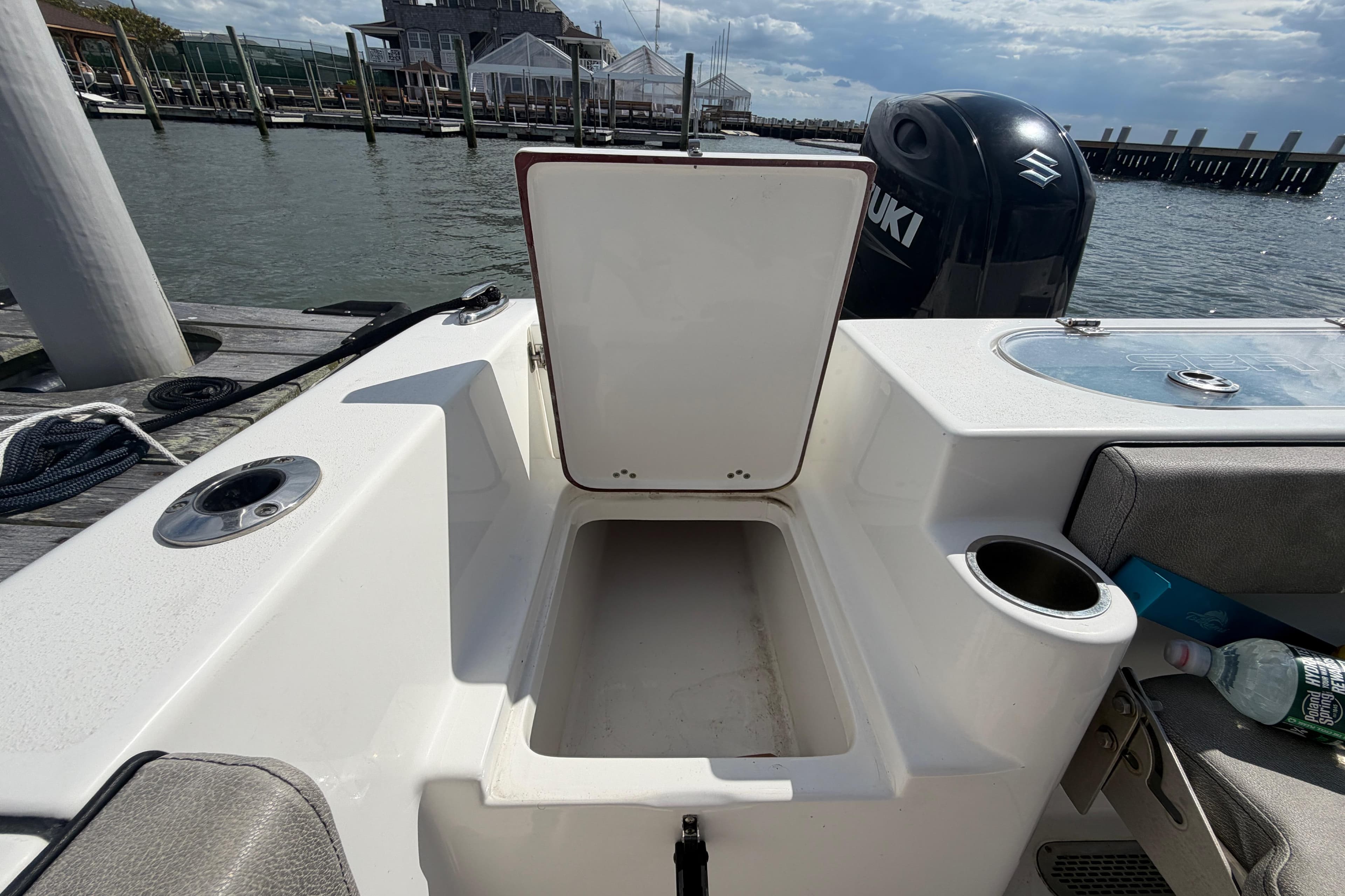 2022 Sea Pro 219 Deep V CC boat with open storage compartment and Suzuki engine.