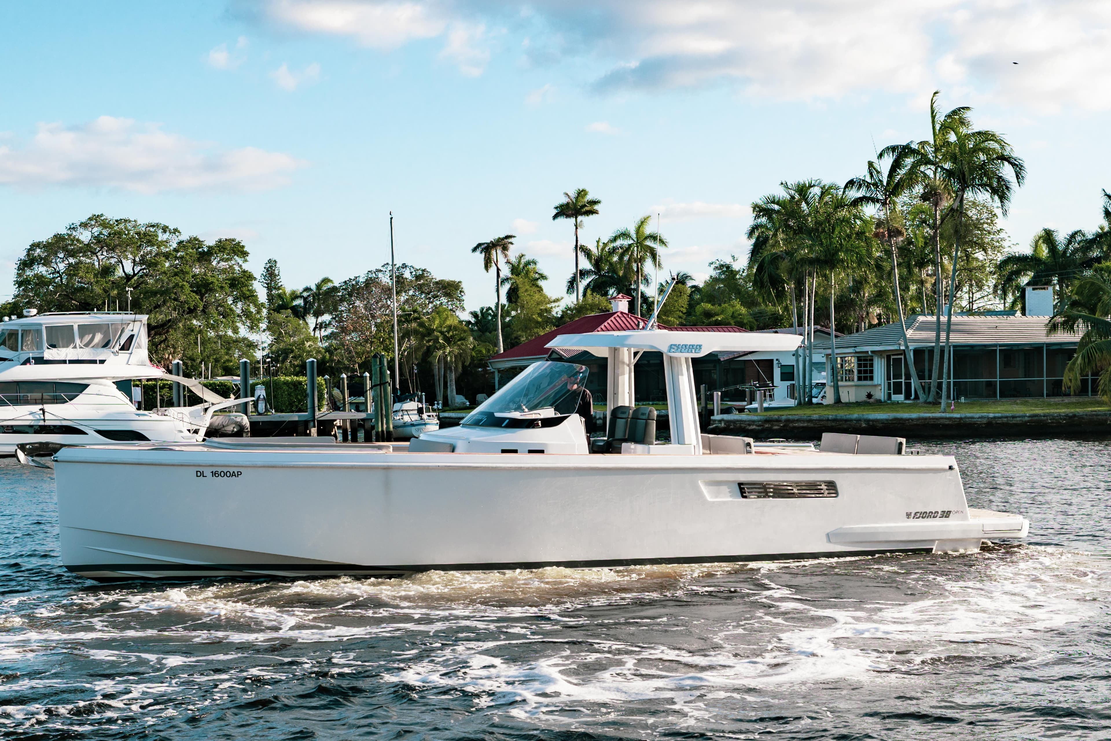 2022 Fjord 38 Open cruising on a scenic waterway with palm trees in the background.