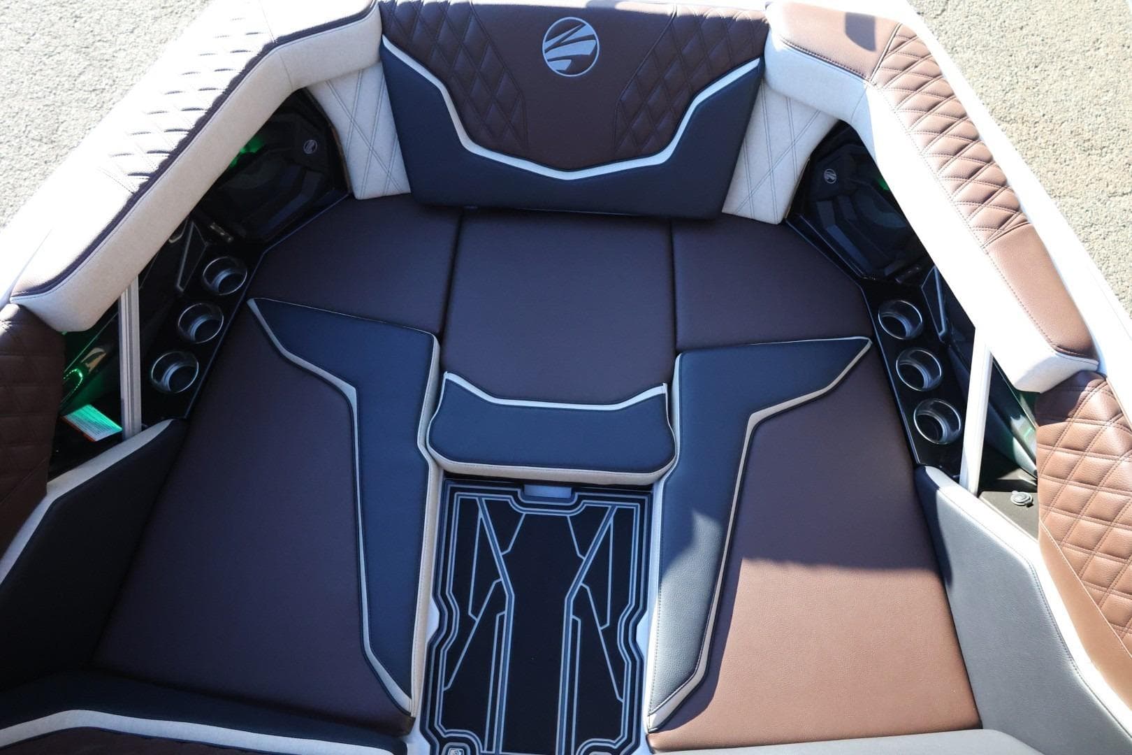 2026 Tigé 24RZX boat interior with brown and white cushioned seating and cup holders.