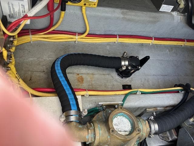 Engine compartment of a 2005 Back Cove Downeast Hardtop boat with visible wiring and hoses.