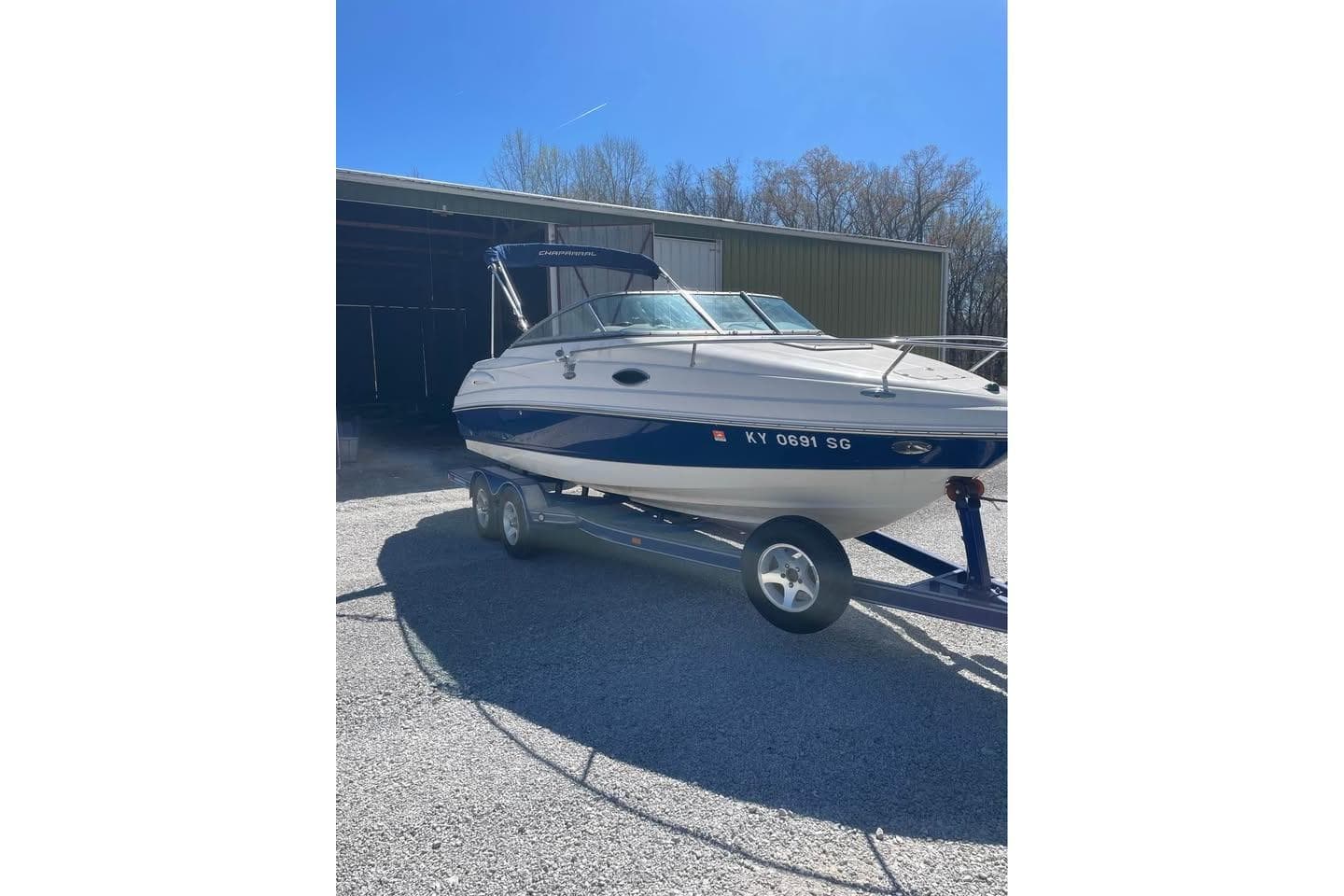 2007 Chaparral 215 SSi boat on trailer, parked outside a storage building.