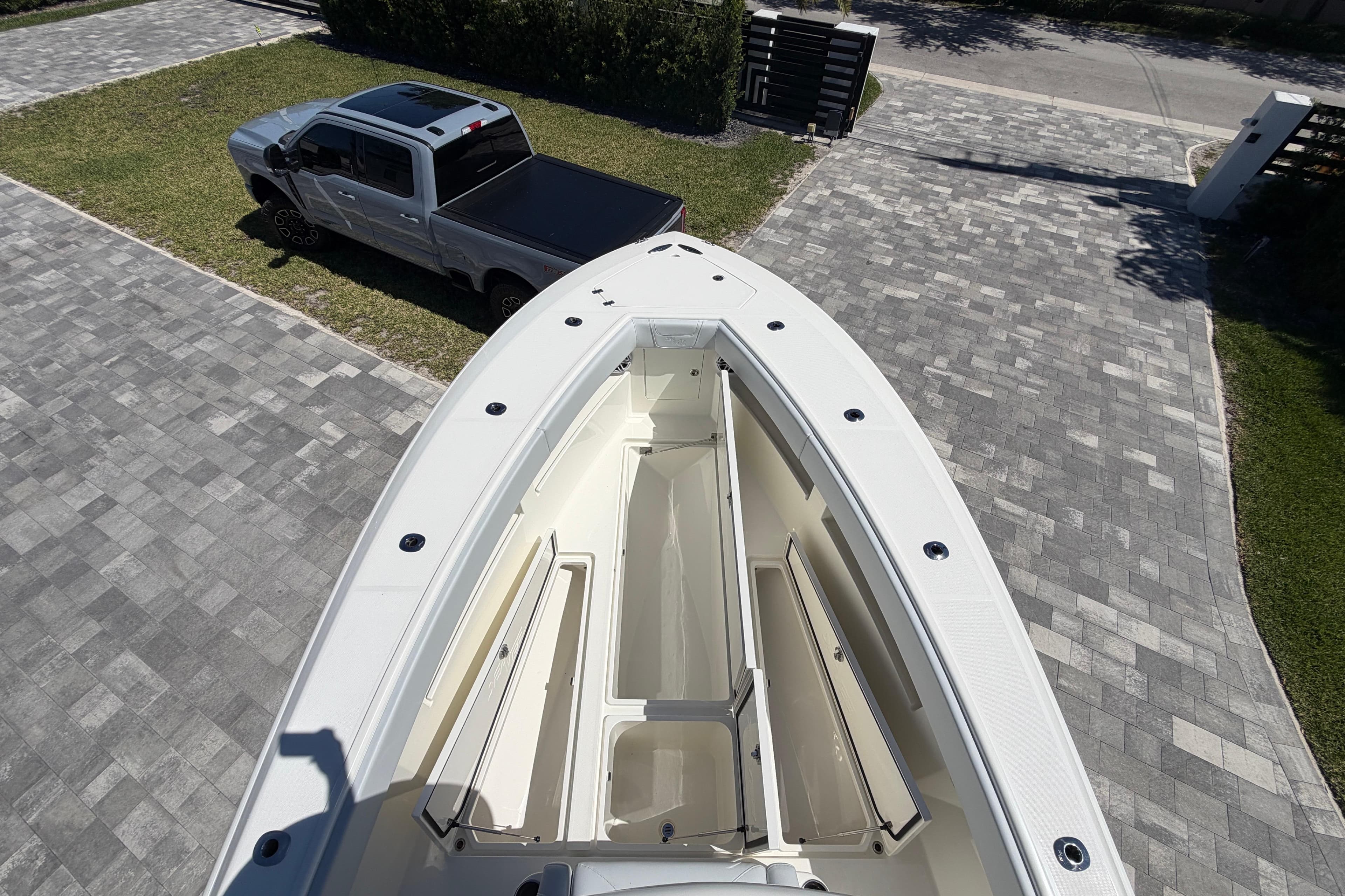 Aerial view of 2021 SeaVee 322Z boat on driveway beside a parked truck.