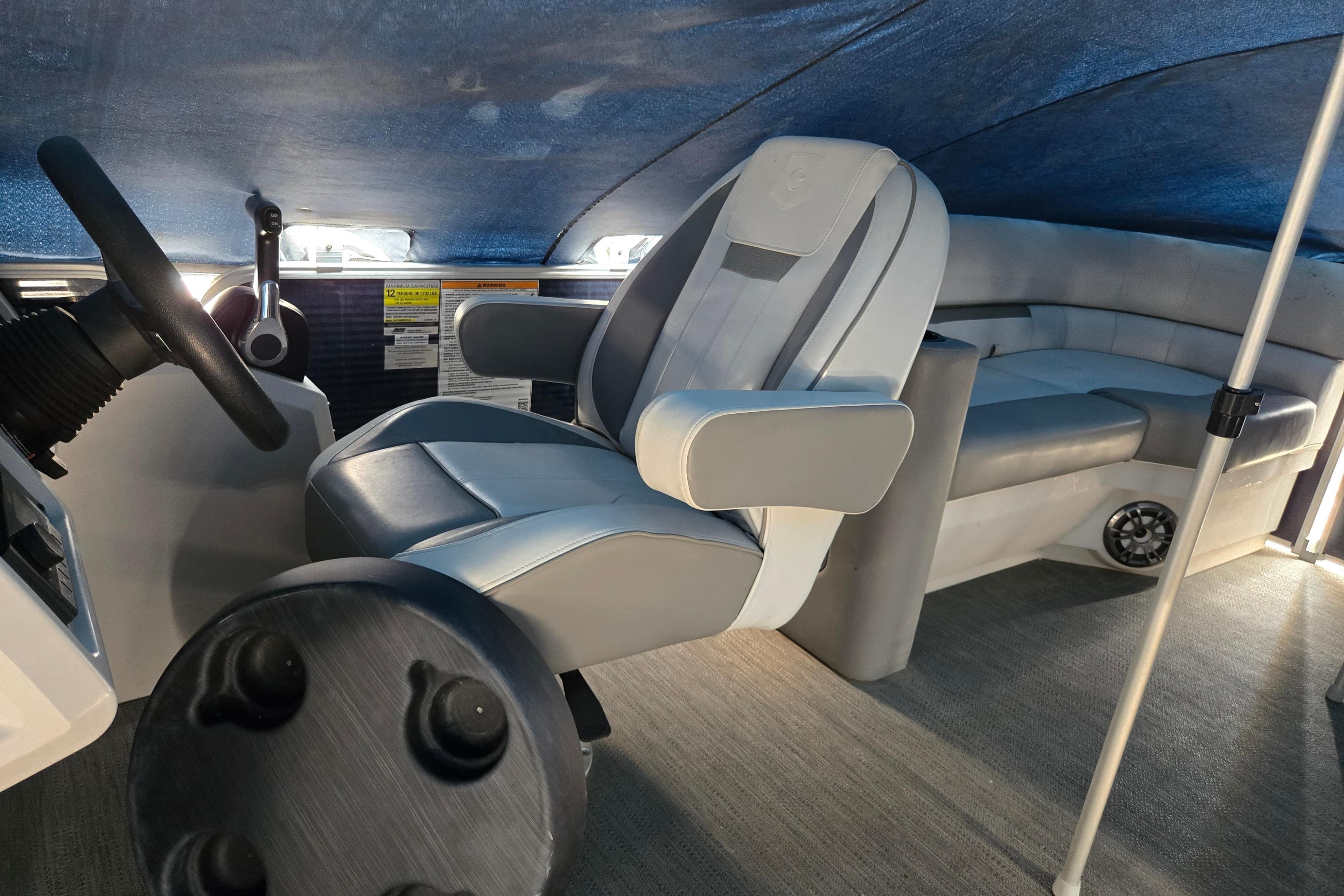 2023 Godfrey Sweetwater 2286 SBX interior with steering wheel and seating under canopy.