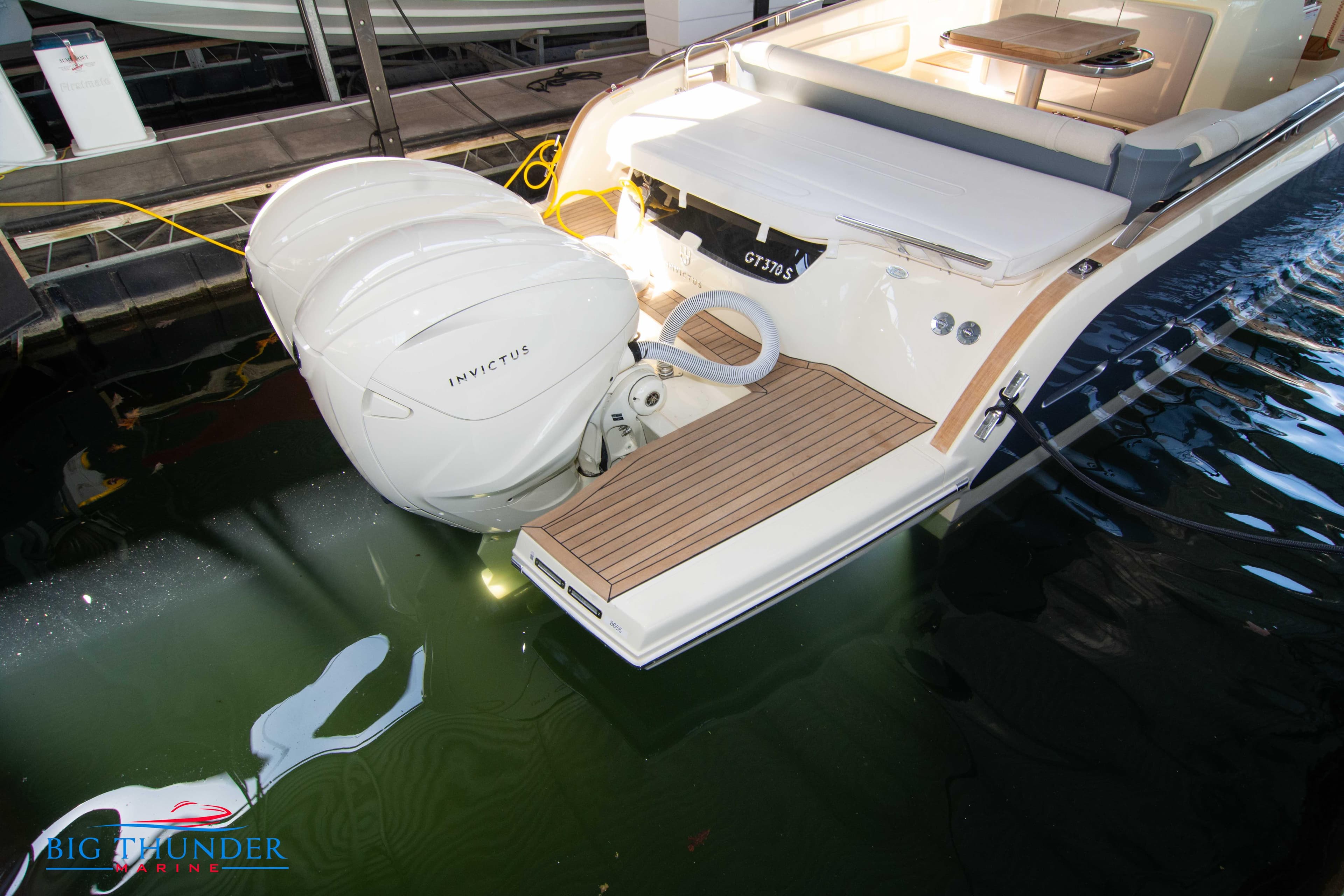 2024 Invictus GT370S luxury boat with twin outboard engines docked.