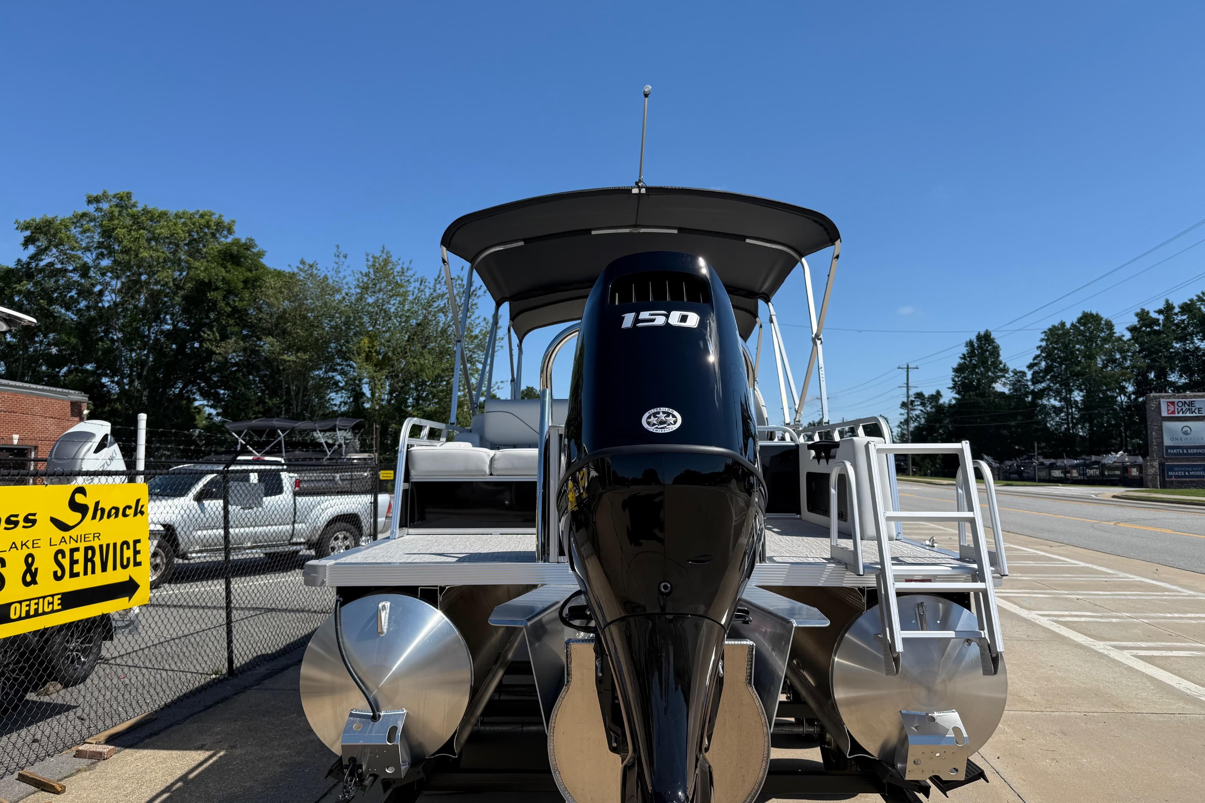 2026 Avalon Venture 85 Versatile rear Bench pontoon boat with 150 HP engine, parked outdoors.