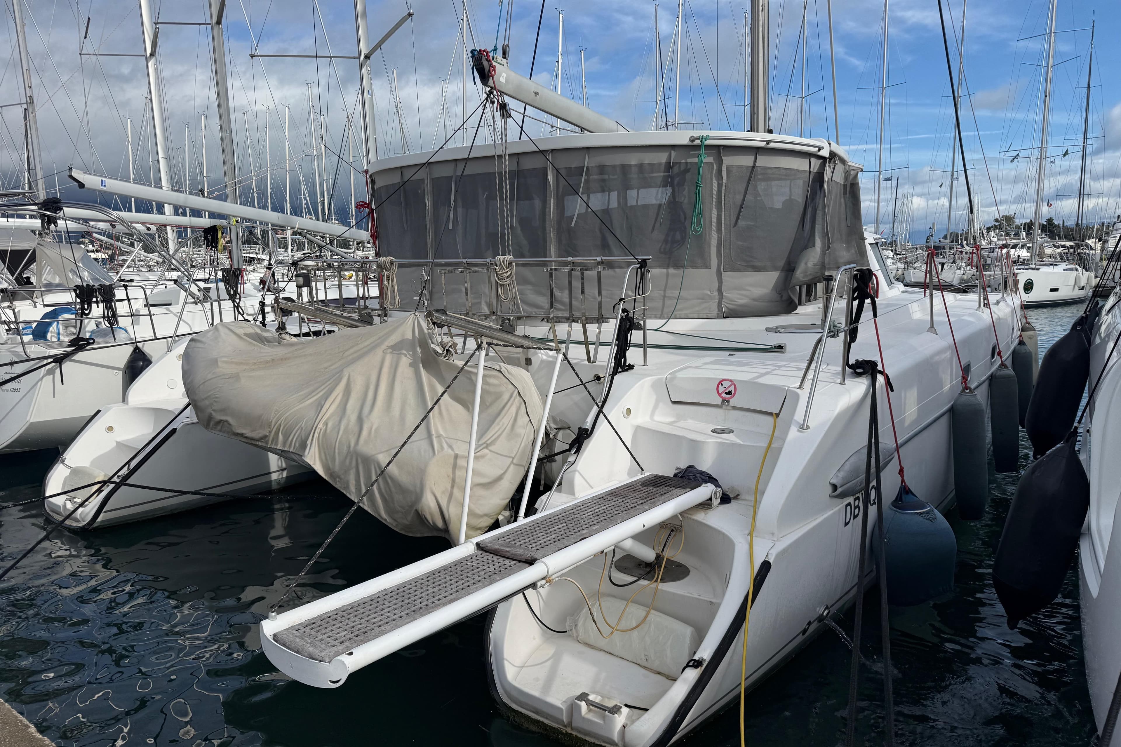 2003 Fountaine Pajot Belize 43 catamaran docked in a marina, surrounded by other boats.