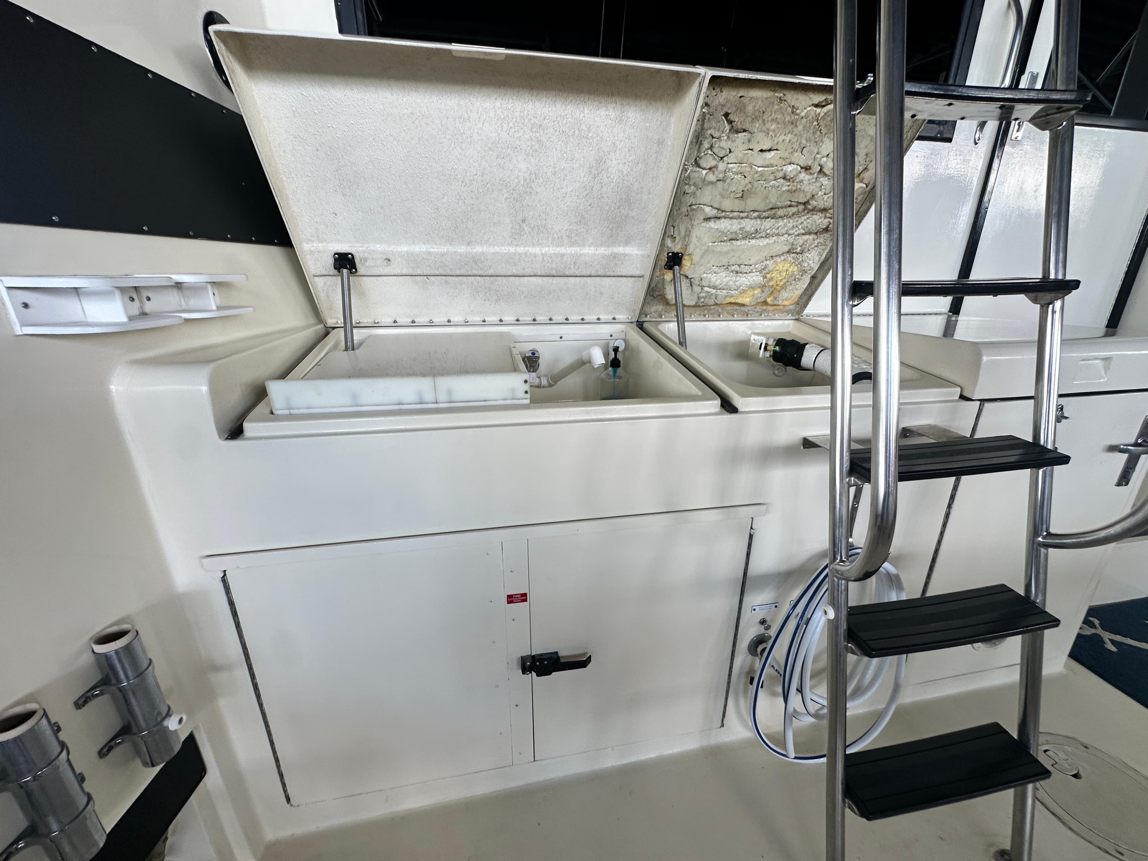 1988 Hatteras Enclosed Bridge Sportfish interior with open storage compartments and ladder.