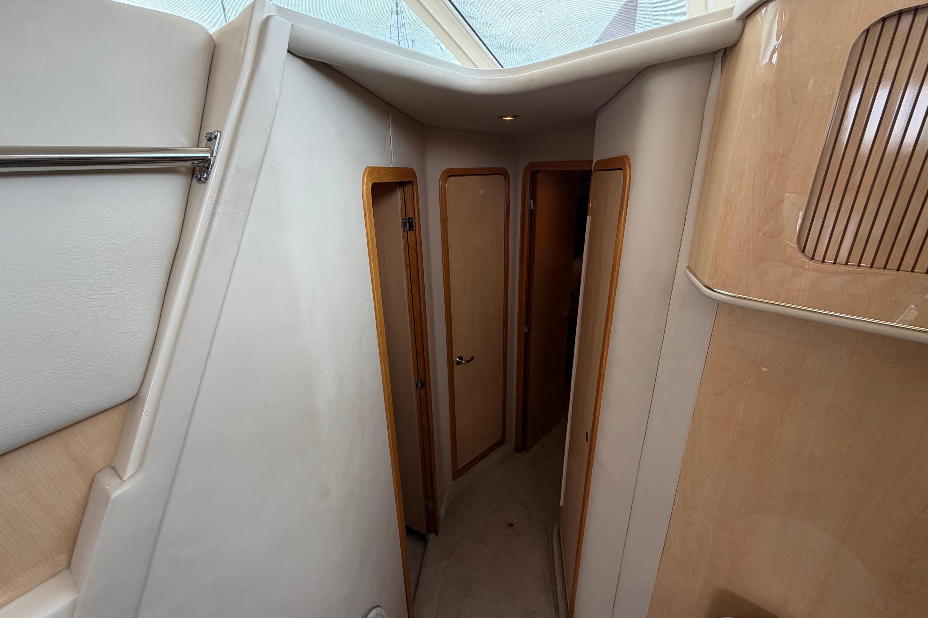 Interior hallway of 2000 Sea Ray 400 Sedan Bridge yacht, featuring wooden doors and modern design.