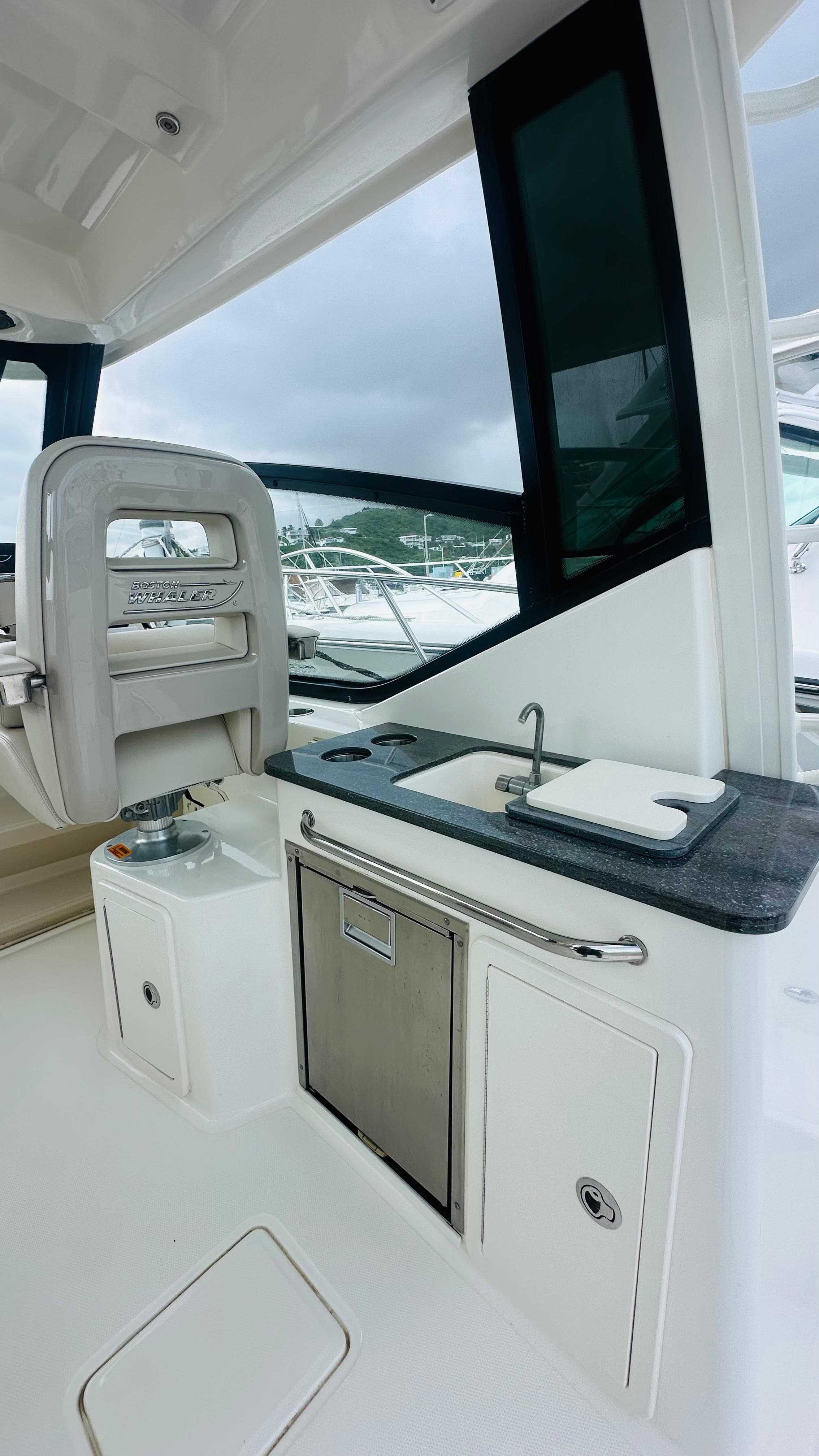2021 Boston Whaler 325 Conquest interior with sink and seating area.