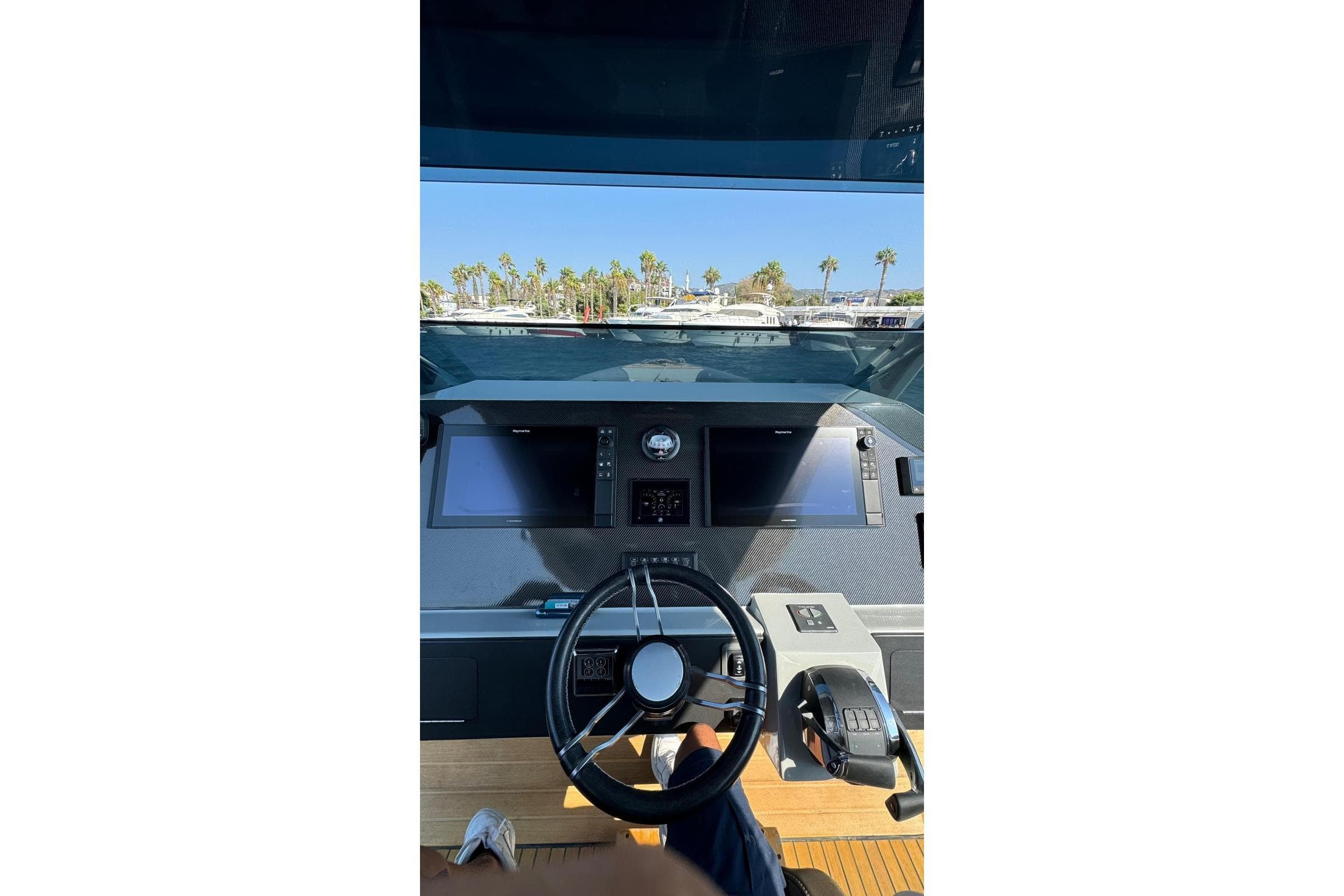 Helm of 2021 Skipper SKIPPER 42 yacht with modern controls and palm trees in background.