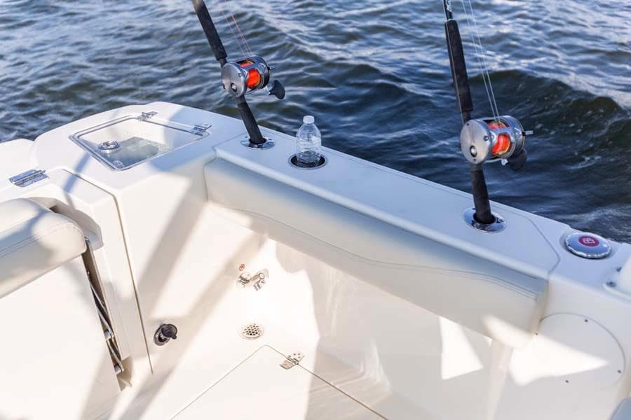 Manufacturer Provided Image: 2025 Cobia 240 Dual Console boat with fishing rods and water bottle on deck.