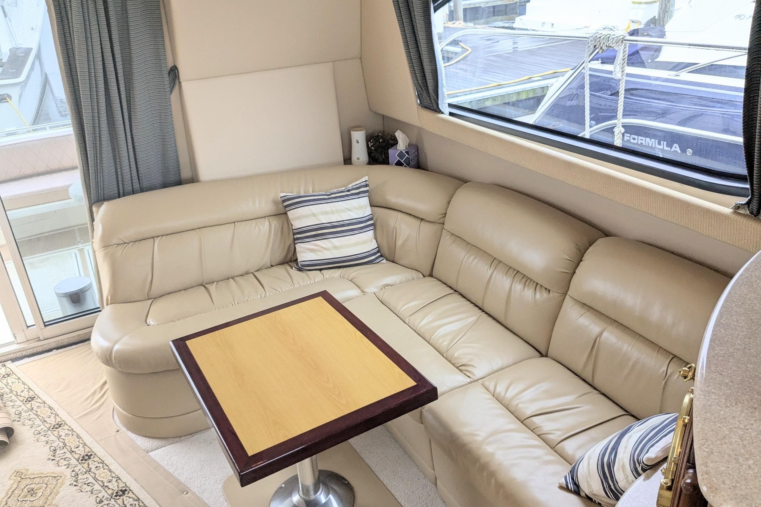 Luxurious interior of 2004 Meridian 411 yacht with leather seating and wooden table.