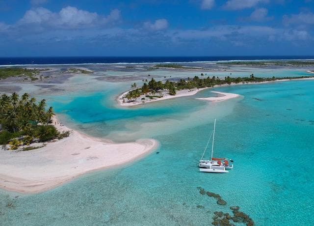 Sailboat anchored near tropical island with turquoise waters, Corsair 37, 2020 model.