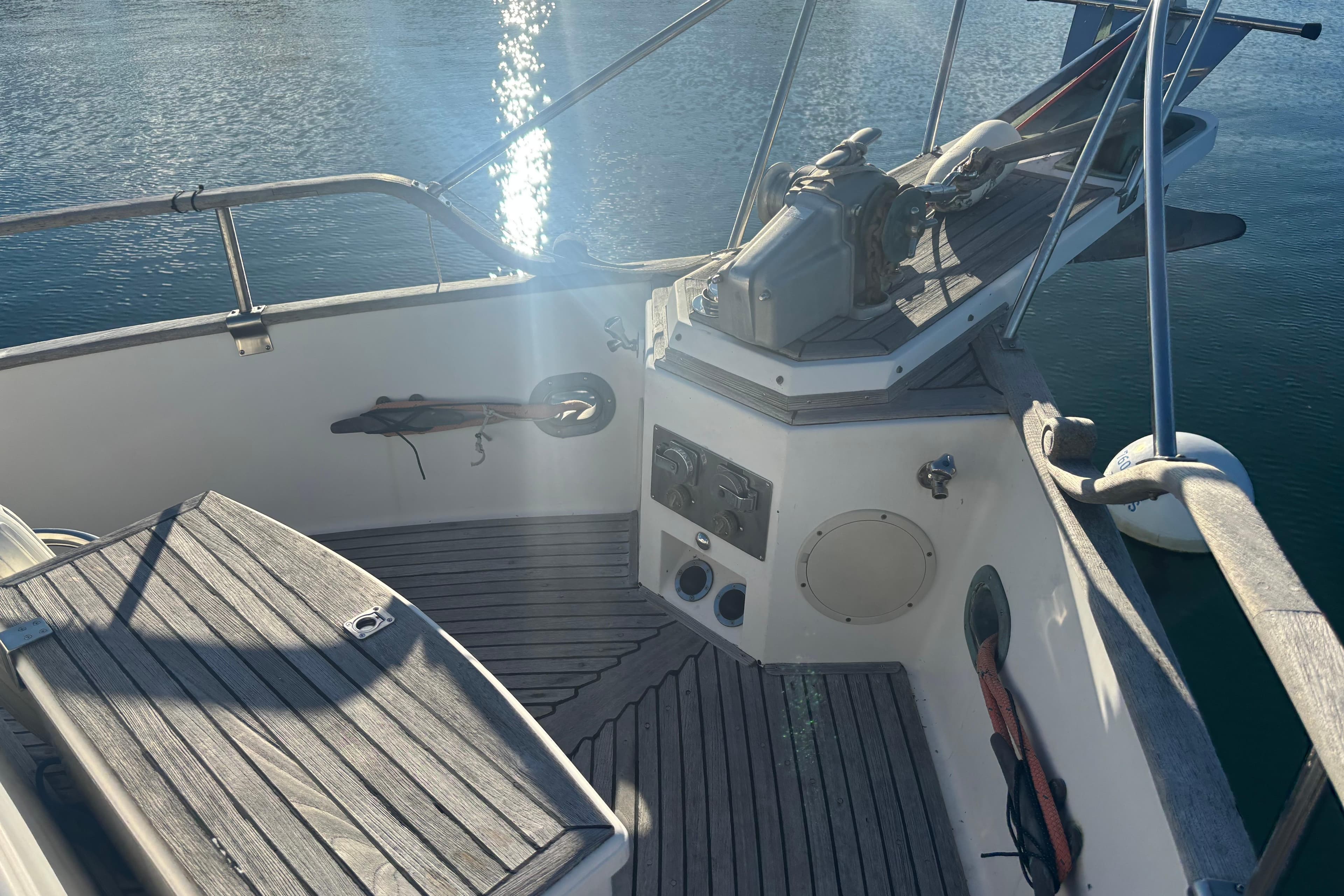 1989 Grand Banks 46 Classic yacht deck with wooden finish and water reflection.