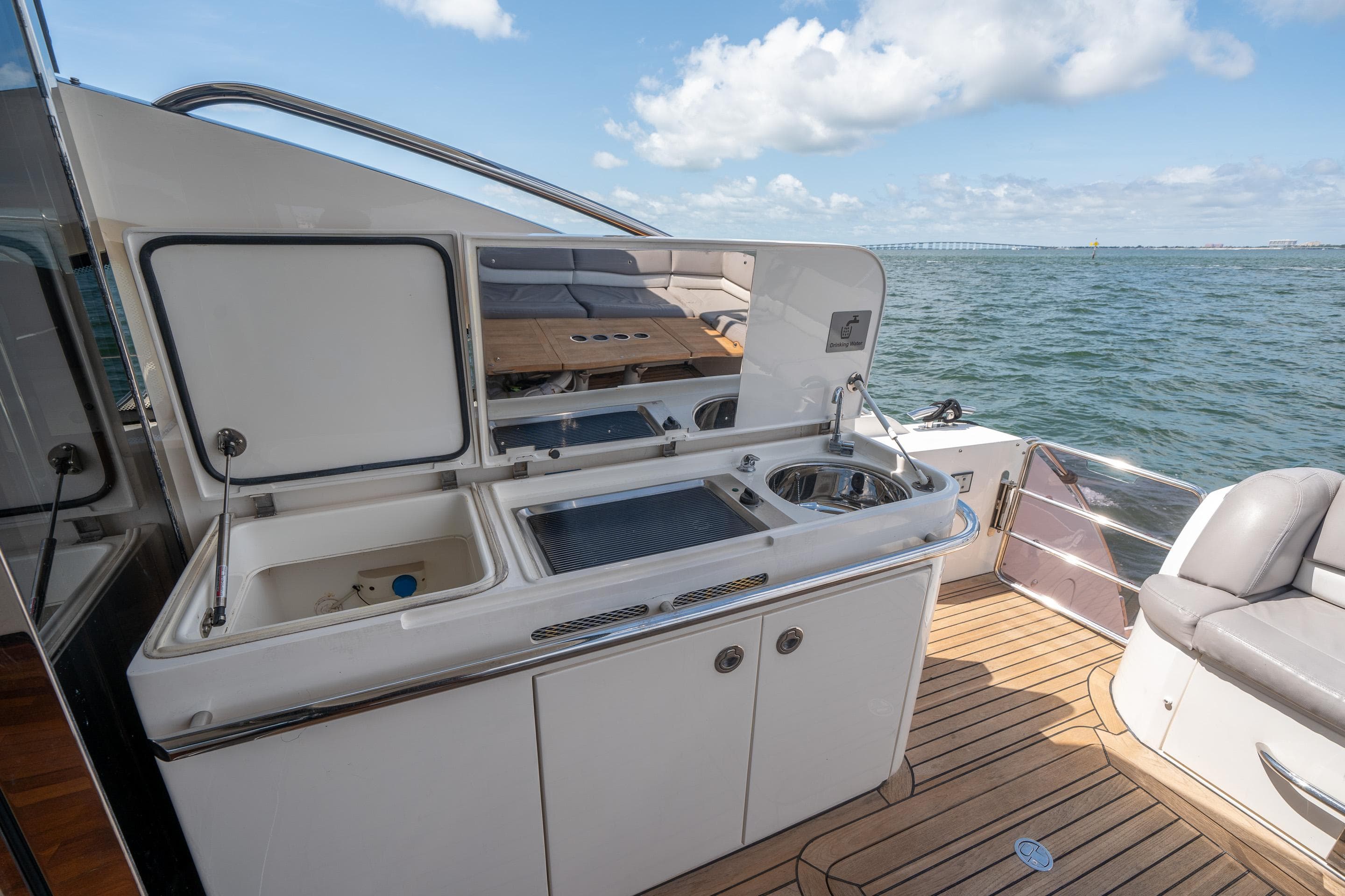 Outdoor kitchen on 2012 Princess V52 yacht with ocean view and teak deck.