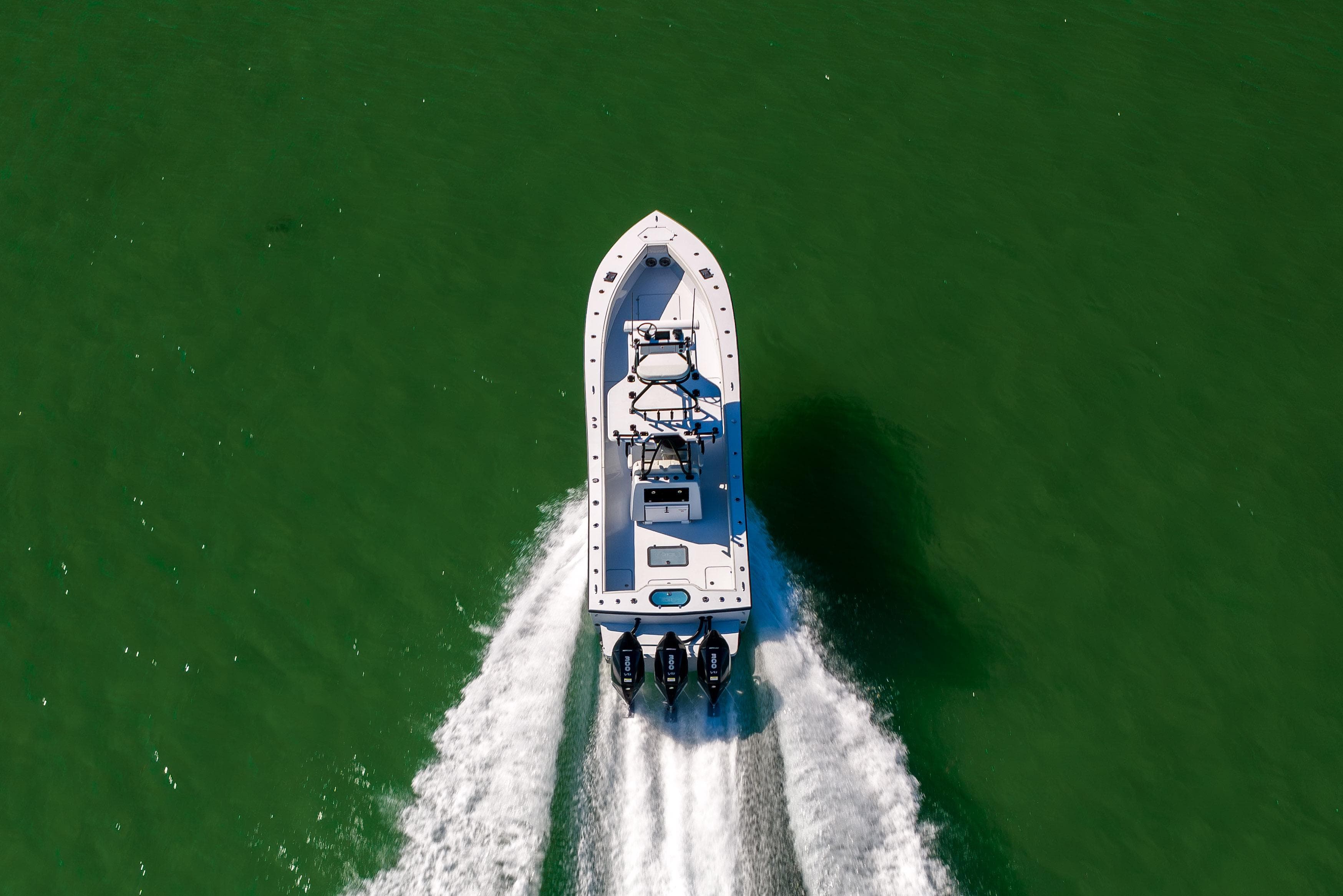 Aerial view of 2025 Conch 33 boat cruising on green water.
