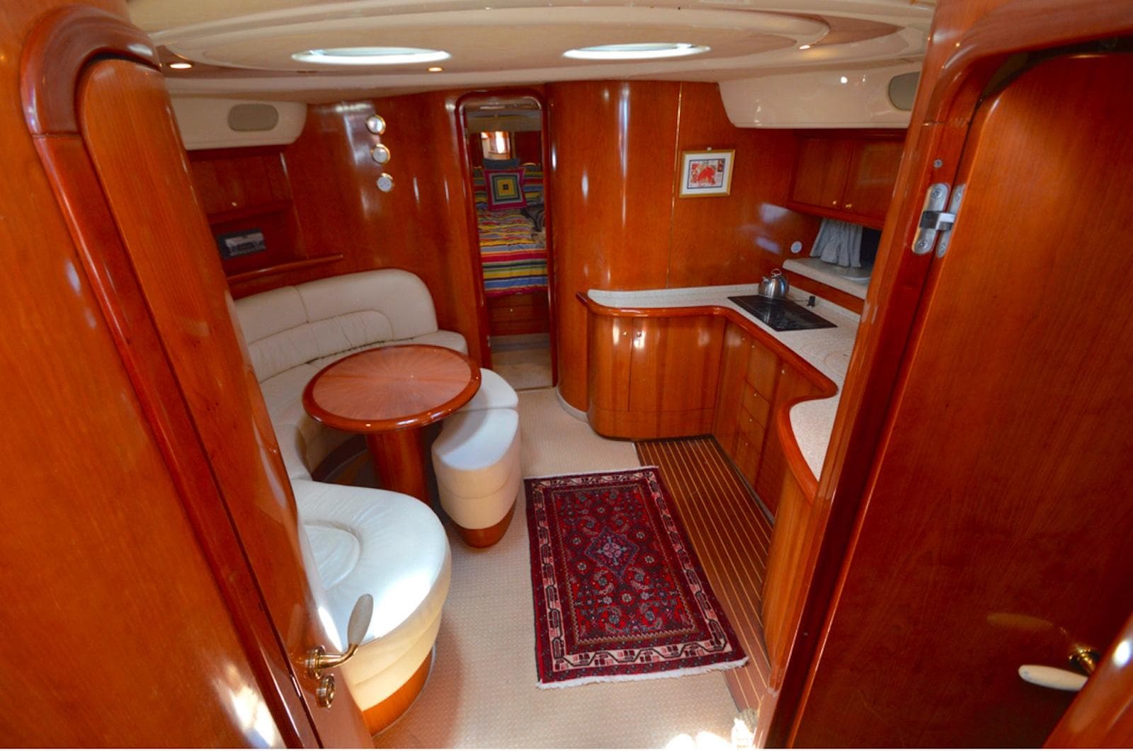 2003 Cranchi 50 Mediterranne yacht interior with wood finish and cozy seating area.
