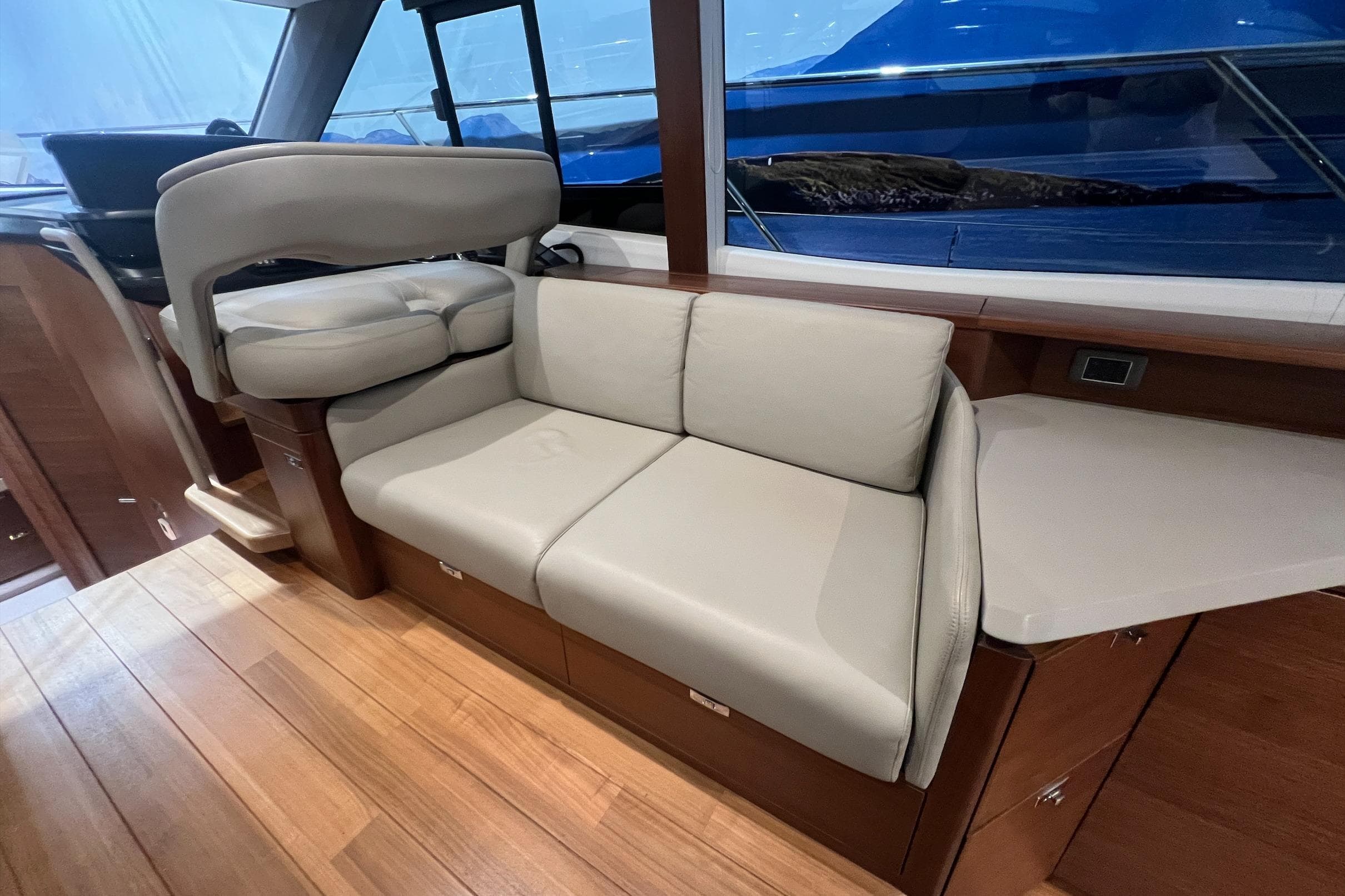 Luxurious interior of 2019 Princess F45 yacht with beige seating and wooden flooring.