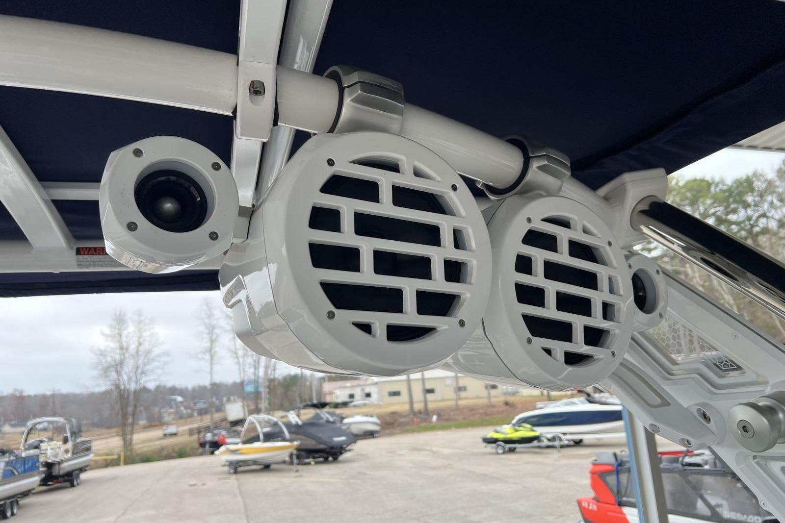 2022 Cobalt R8 Surf boat speakers and camera on deck, marina background.