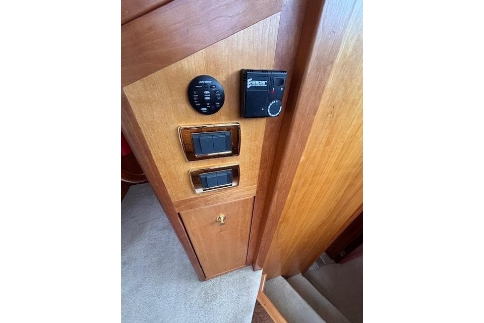 Control panel inside 2004 Canoe Cove Sedan with switches and dials on wooden panel.