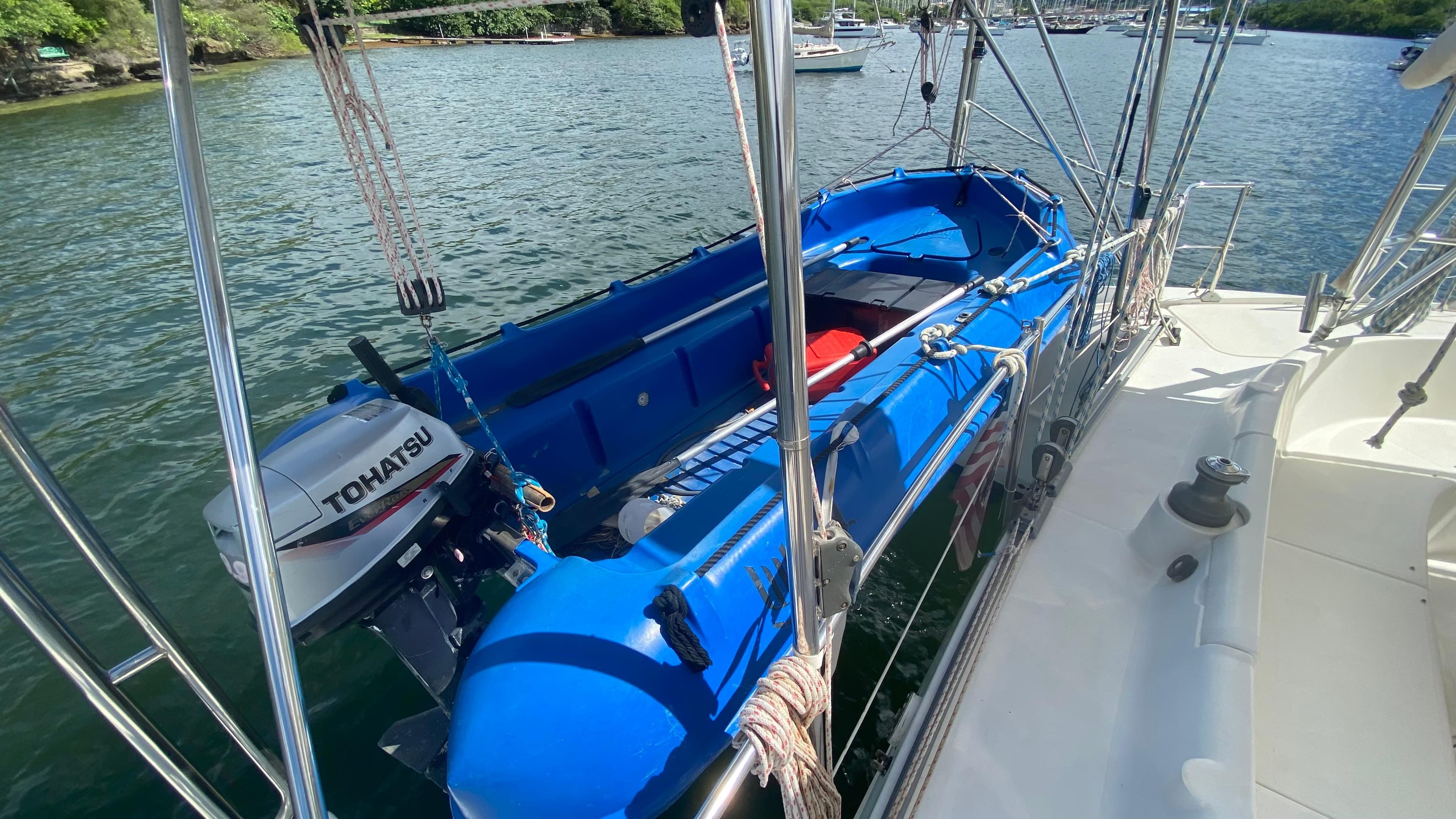 Blue dinghy with Tohatsu motor on Fountaine Pajot Bahia 46 catamaran, 1998 model, docked in water.