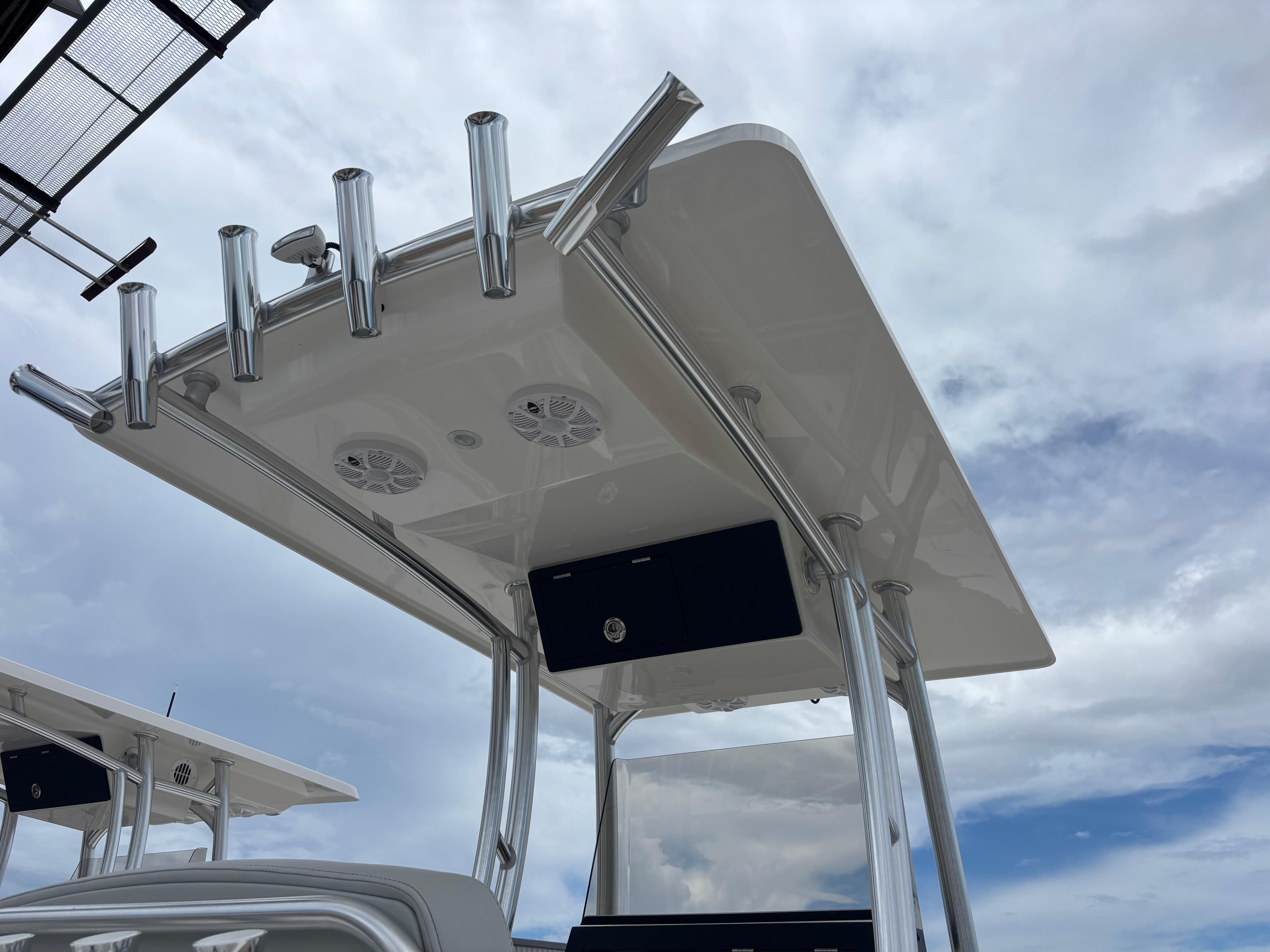 2026 Bay Rider 219 Bay boat with T-top and rod holders against cloudy sky.