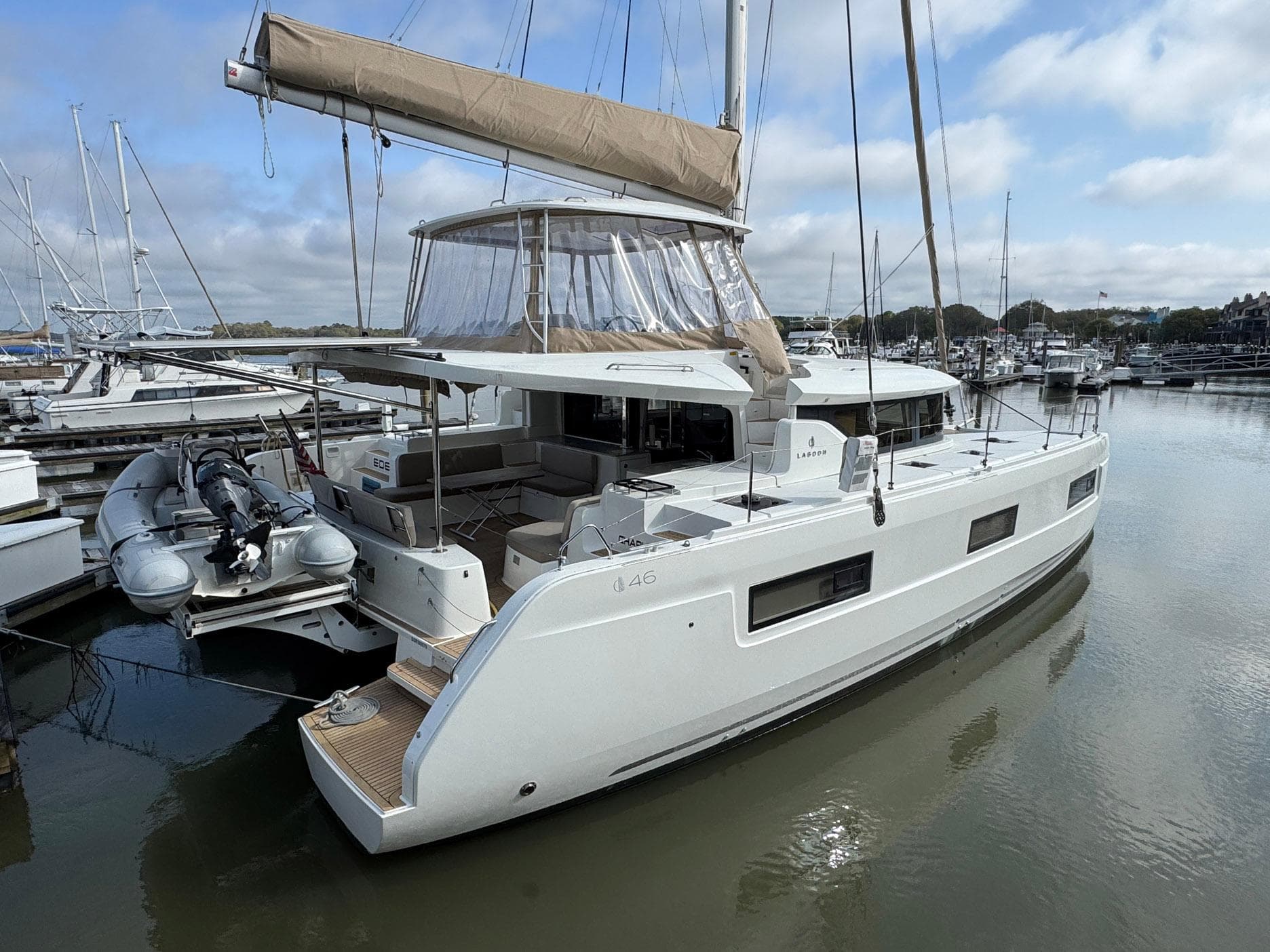 2022 Lagoon 46 catamaran docked at marina, featuring modern design and spacious deck.
