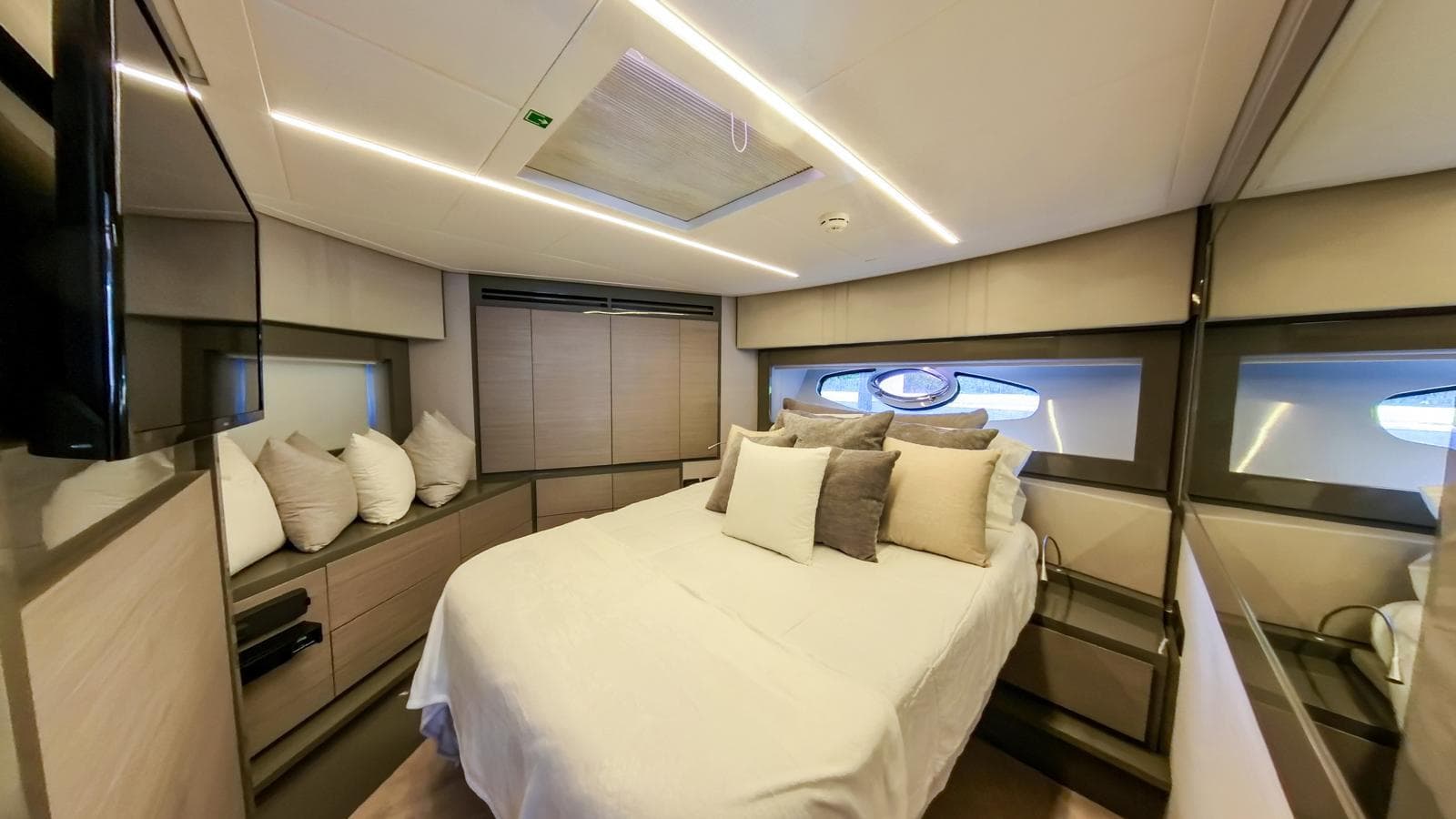 Luxurious bedroom interior of 2014 Pershing 62 yacht with modern design and cozy bedding.