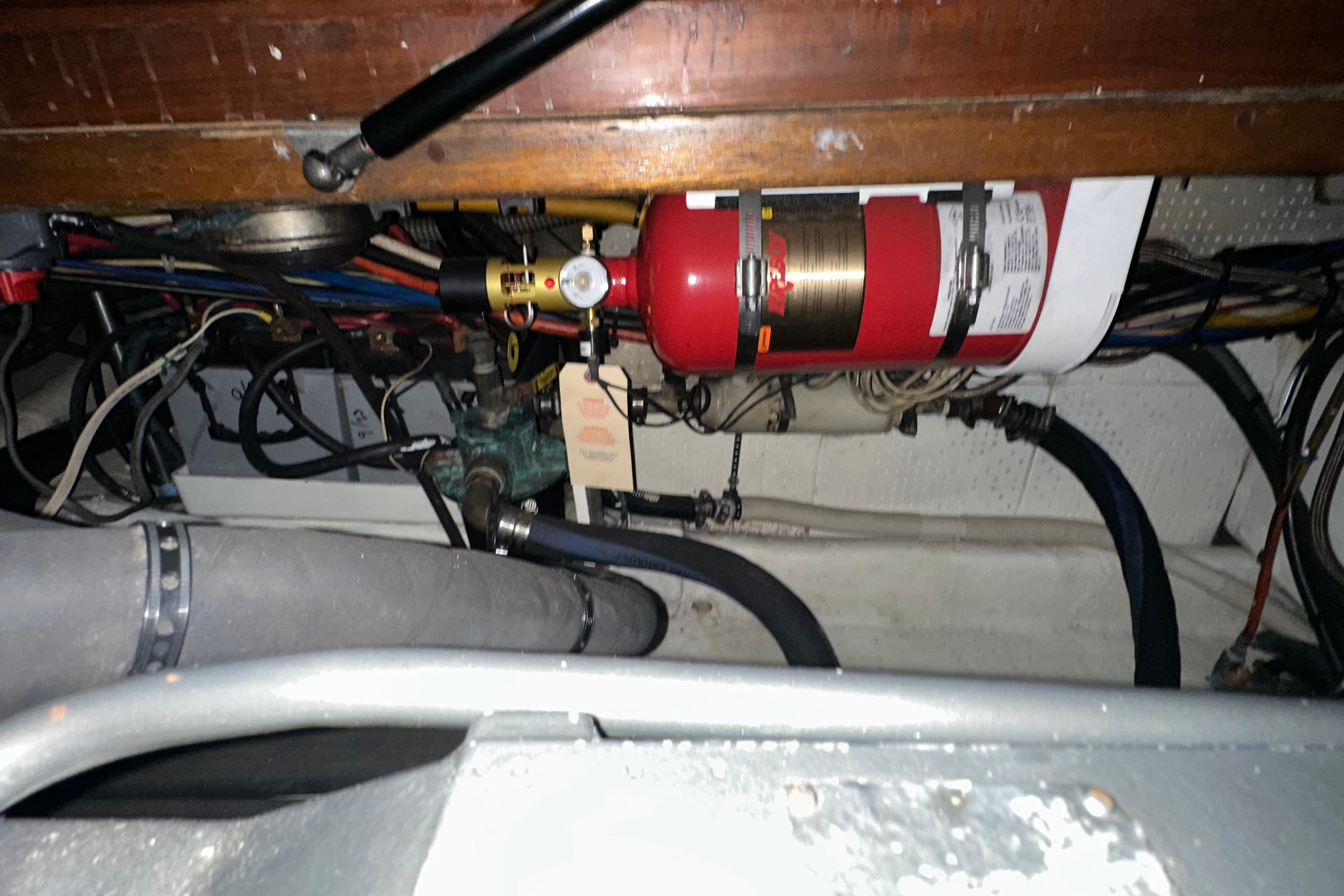 Engine room of 1987 Kadey-Krogen Manatee 36 with fire extinguisher and wiring.