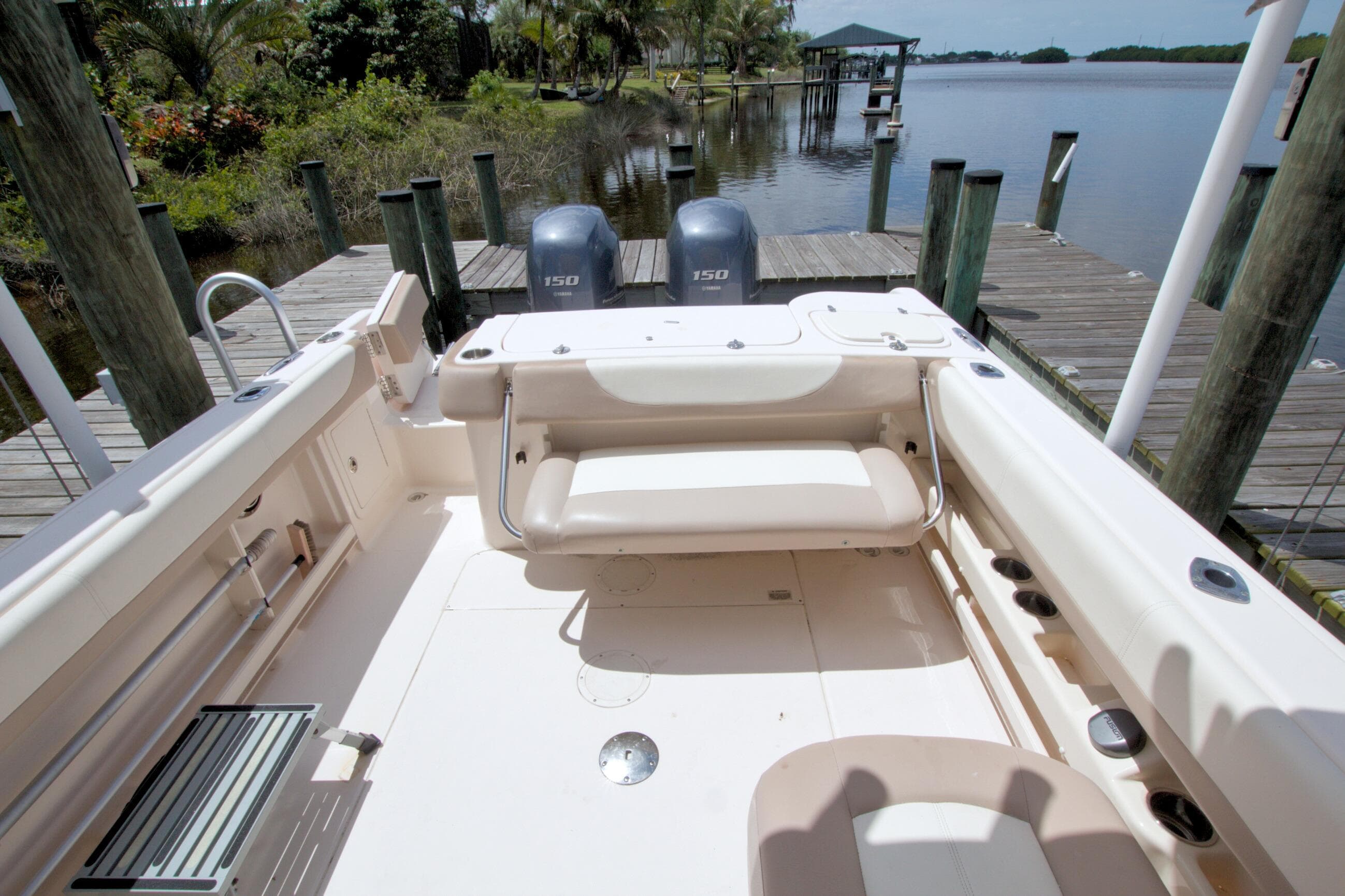 2013 Grady-White Freedom 275 boat interior with dual engines, docked by a scenic waterfront.