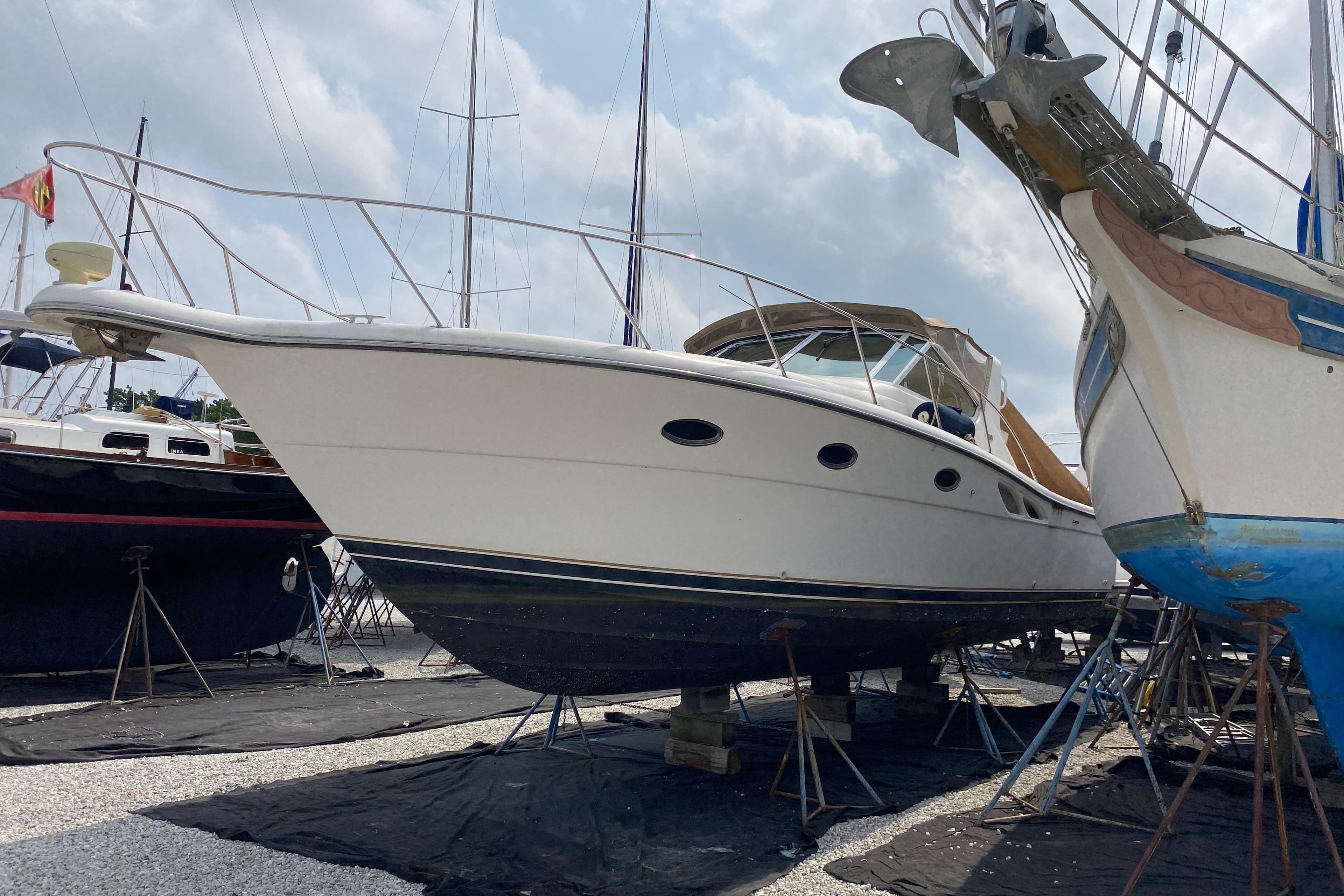1999 Tiara Yachts 3500 Open on dry dock, surrounded by other boats under a cloudy sky.
