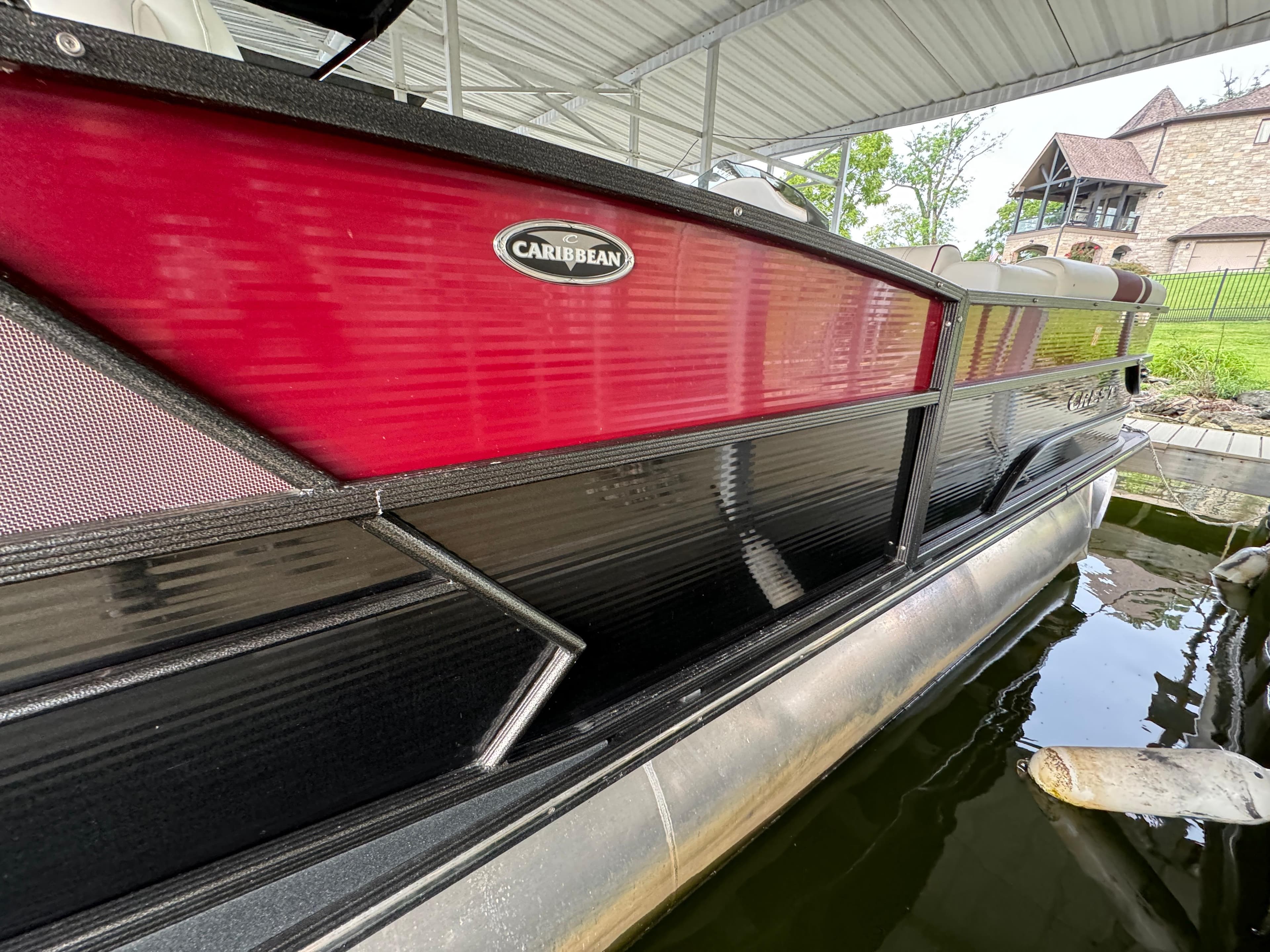 2019 Crest Caribbean 250 SLRC pontoon boat docked under a canopy.