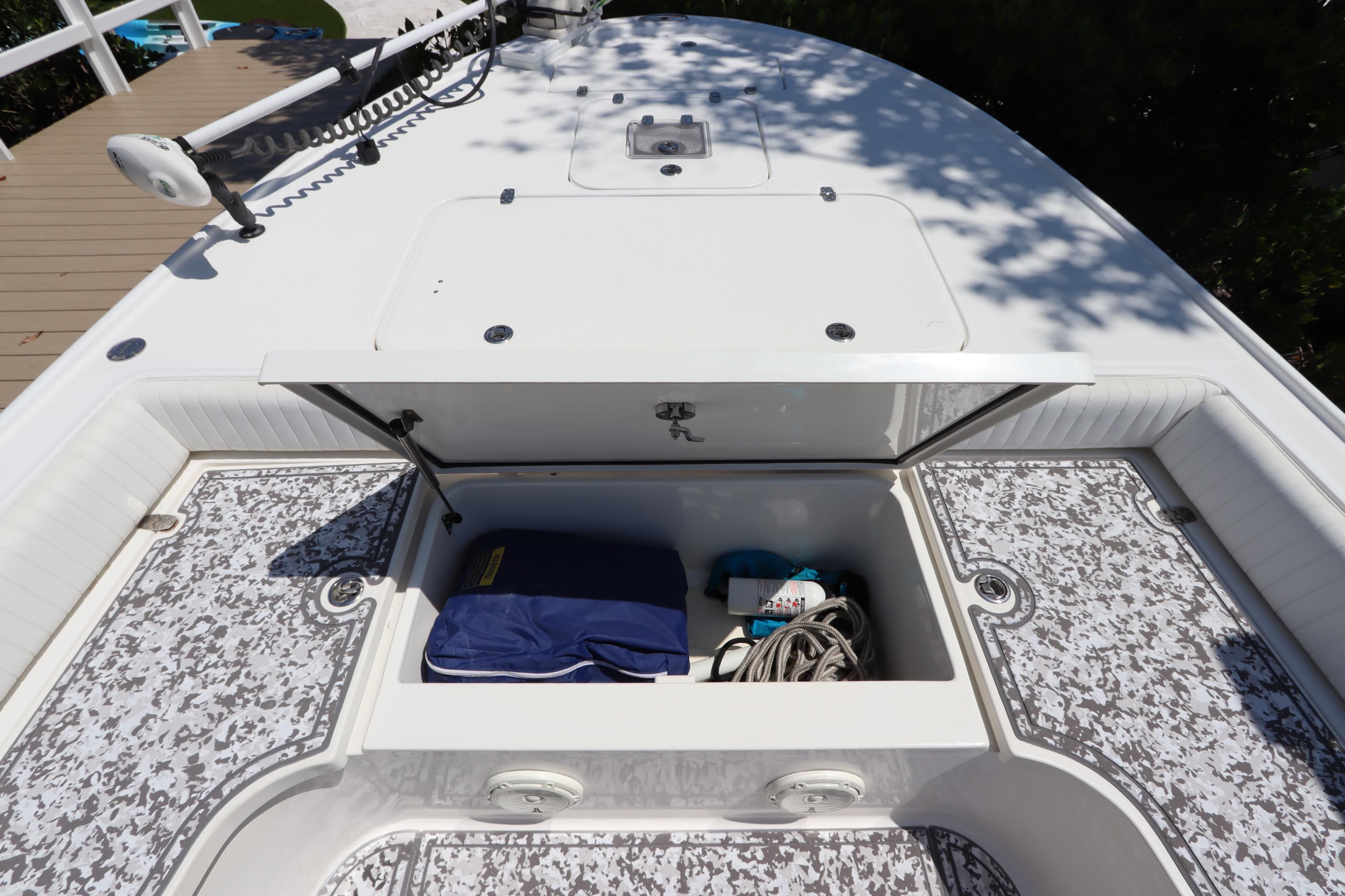 Open storage compartment on 2014 Canyon Bay 2400 boat, containing rope and equipment.