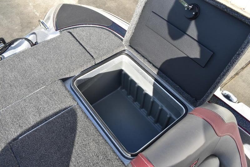 Open storage compartment in 2026 Triton 179 TrX boat, featuring carpeted interior.