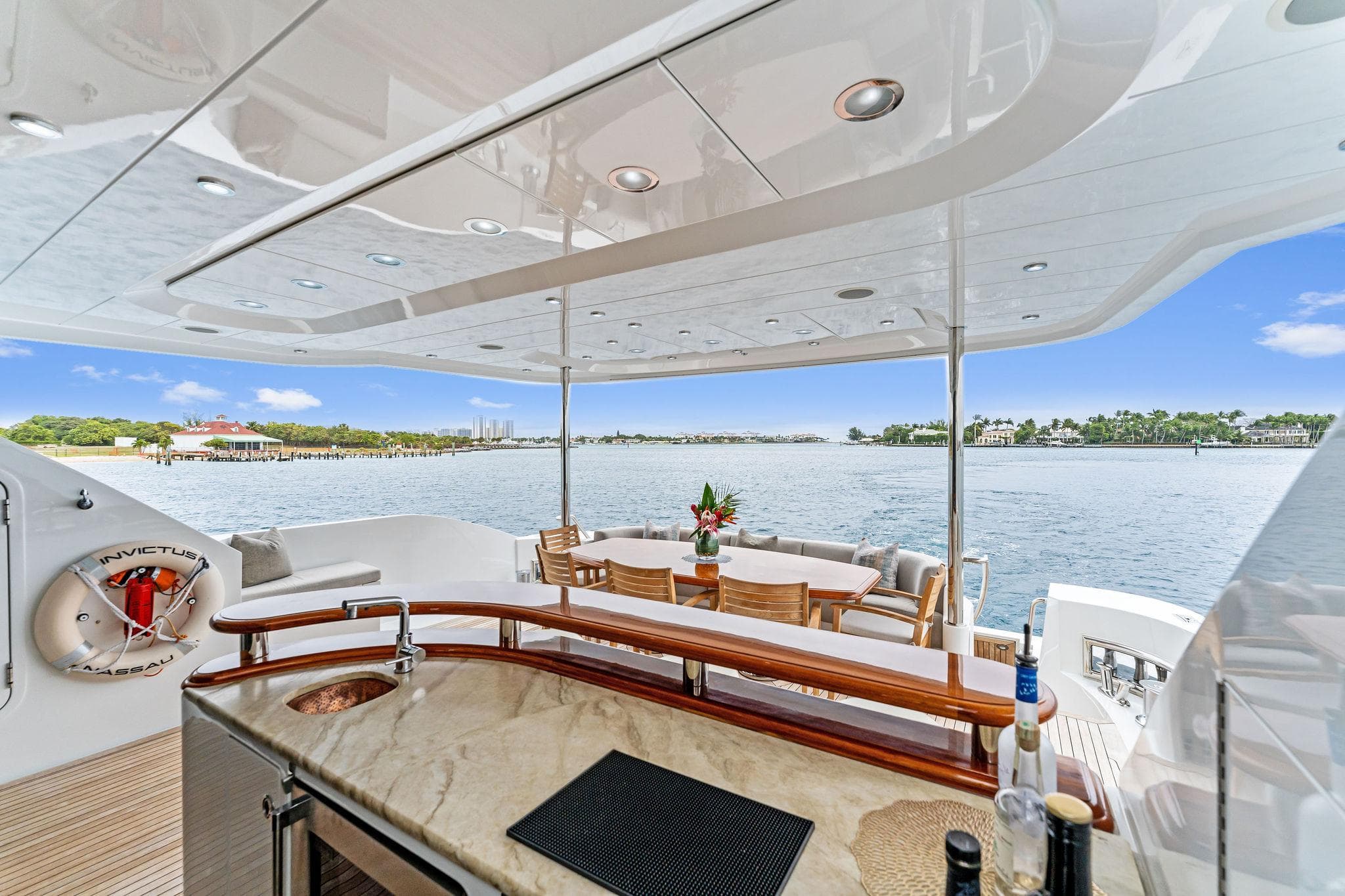 Luxurious 2006 Palmer Johnson motor yacht deck with bar and dining area overlooking the water.