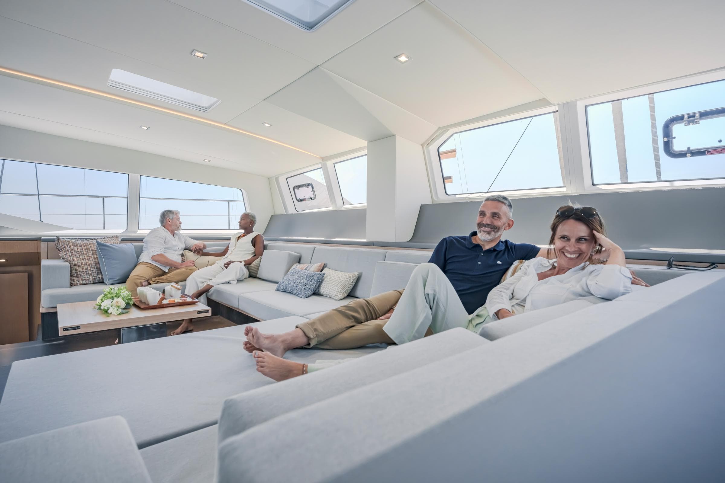 Luxurious interior of 2025 Privilege Signature 650 yacht with relaxed passengers.