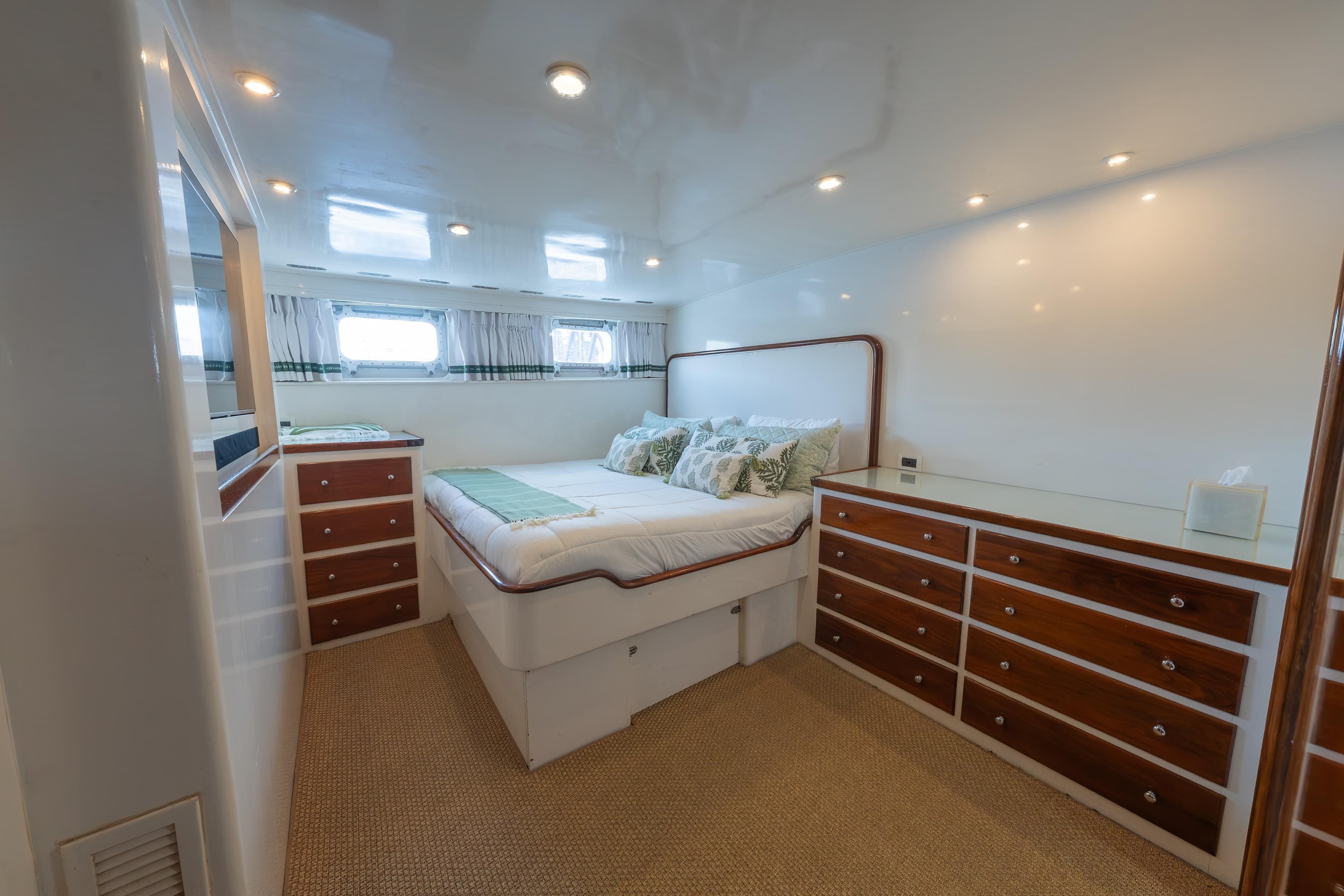 Luxurious bedroom interior of 1939 Mathis Trumpy Fantail Houseboat with elegant wood accents.